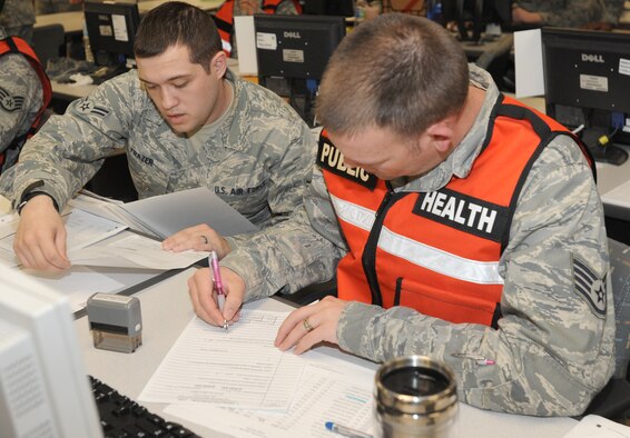 U.S. Air Force Airman 1st Class Joshua Frazer, left, and Staff Sgt. Richard Blake, 35th Aerospace Medicine Squadron public health technicians, process Airmen through the personnel deployment function line during an operational readiness exercise at Misawa Air Base, Japan, April 28, 2012. The purpose of the PDF process is to ensure Airmen have pre-deployment paperwork accomplished prior to supporting contingencies abroad. (U.S. Air Force photo by Airman Kenna Jackson/Released)