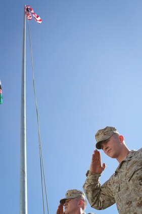 Sergeant Bryce W. Cherryholmsnoll, a native of Huxley, Iowa, and Cpl. Gregory C. Verhelle, a native of Kansas City, Mo., both serving with Task Force Leatherneck, 1st Marine Division (Forward), salutes as the American flag is raised over the Task Force Leatherneck compound here April 28, 2012. Marines serving here have the opportunity to fly a 3-by-5-foot American flag for a day and dedicate it to someone of their choice.