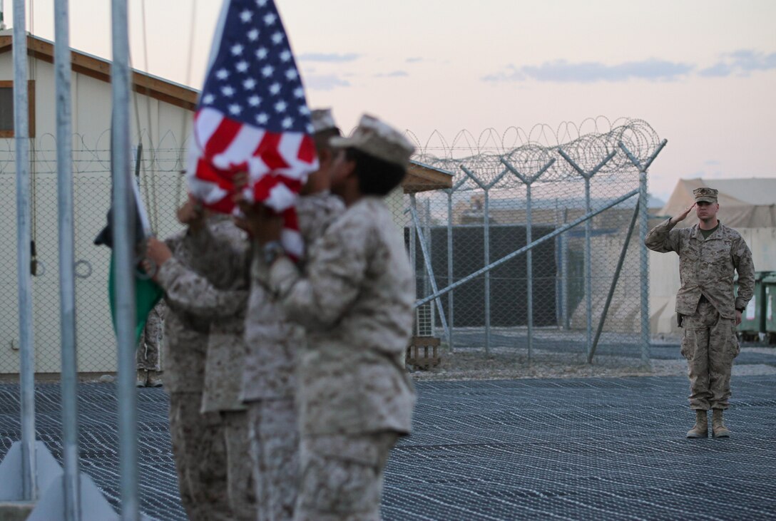 First Lt. Phillip M. Downey, a native of St. Louis serving in the command operations center at the Task Force Leatherneck compound here, salutes as the American flag is lowered during sunset April 28, 2012. Downey is sending his unborn son the flag that flew from sunup to sundown that day as a dedication. Downey is currently serving a year deployment to Helmand province with 1st Marine Division (Forward) and said he doesn’t think he’ll be able to make it home in time to see his son born.