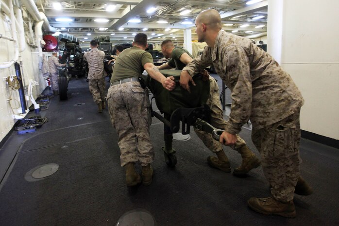 Artillery Marines with 3rd Battalion, 10th Marine Regiment, attached to Battalion Landing Team 1st Battalion, 2nd Marine Regiment, 24th Marine Expeditionary Unit, push an M-777 155 mm Howitzer to the flight deck of the USS New York in preparation for quarterly maintenance  here, April 28, 2012. The 24th MEU is currently deployed with the Navy's Iwo Jima Amphibious Ready Group as a theater reserve and crisis response force capable of a variety of missions from full-scale combat operations to humanitarian assistance and disaster relief.