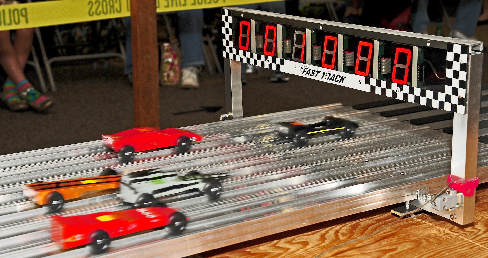 WARRENSBURG, Mo. -- Model cars built and designed by Cub Scouts from Whiteman Air Force Base and Cub Scouts from six cities in the local area speed through the finish line of a Cub Scout District Pine Wood Derby at First United Methodist Church April 14. Cub Scouts participate in activities such as Pine Wood Derbies every month to instill team building and leadership skills in the boys. (U.S. Air Force photo/Senior Airman Nick Wilson)