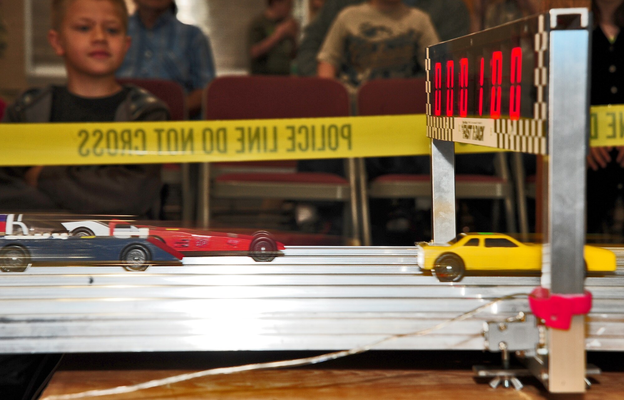 WARRENSBURG, Mo. -- Model cars built and designed by Cub Scouts from Whiteman Air Force Base and Cub Scouts from six cities in the local area speed through the finish line of a Cub Scout District Pine Wood Derby at First United Methodist Church April 14. The annual derby was sponsored by Boy Scouts of America and provided an opportunity for Cubs from Whiteman Air Force Base and six cities in the local area to work on a project with their parents, learn about aerodynamics and have fun. (U.S. Air Force photo/Senior Airman Nick Wilson)