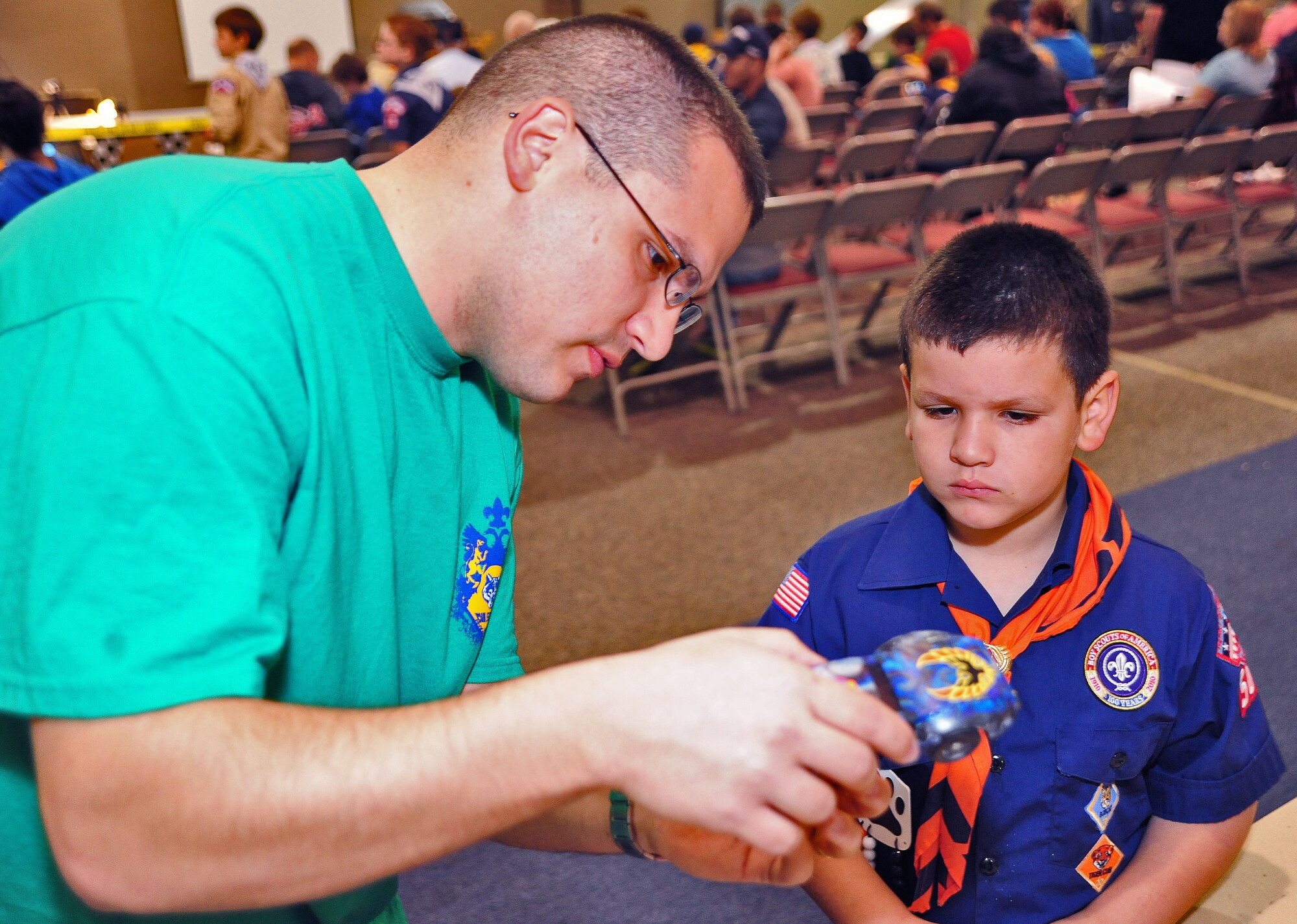 WARRENSBURG, Mo. -- Staff Sgt. Rafael Franjul, 509th Bomb Wing Judge Advocate civil law paralegal, helps his son, Joshua, apply the final touches to his model car during a Cub Scout District Pinewood Derby at First United Methodist Church April 14. Cub Scouts from Whiteman Air Force Base, Knob Noster, Warrensburg and four other cities in the local area attended the event. (U.S. Air Force photo/Senior Airman Nick Wilson)