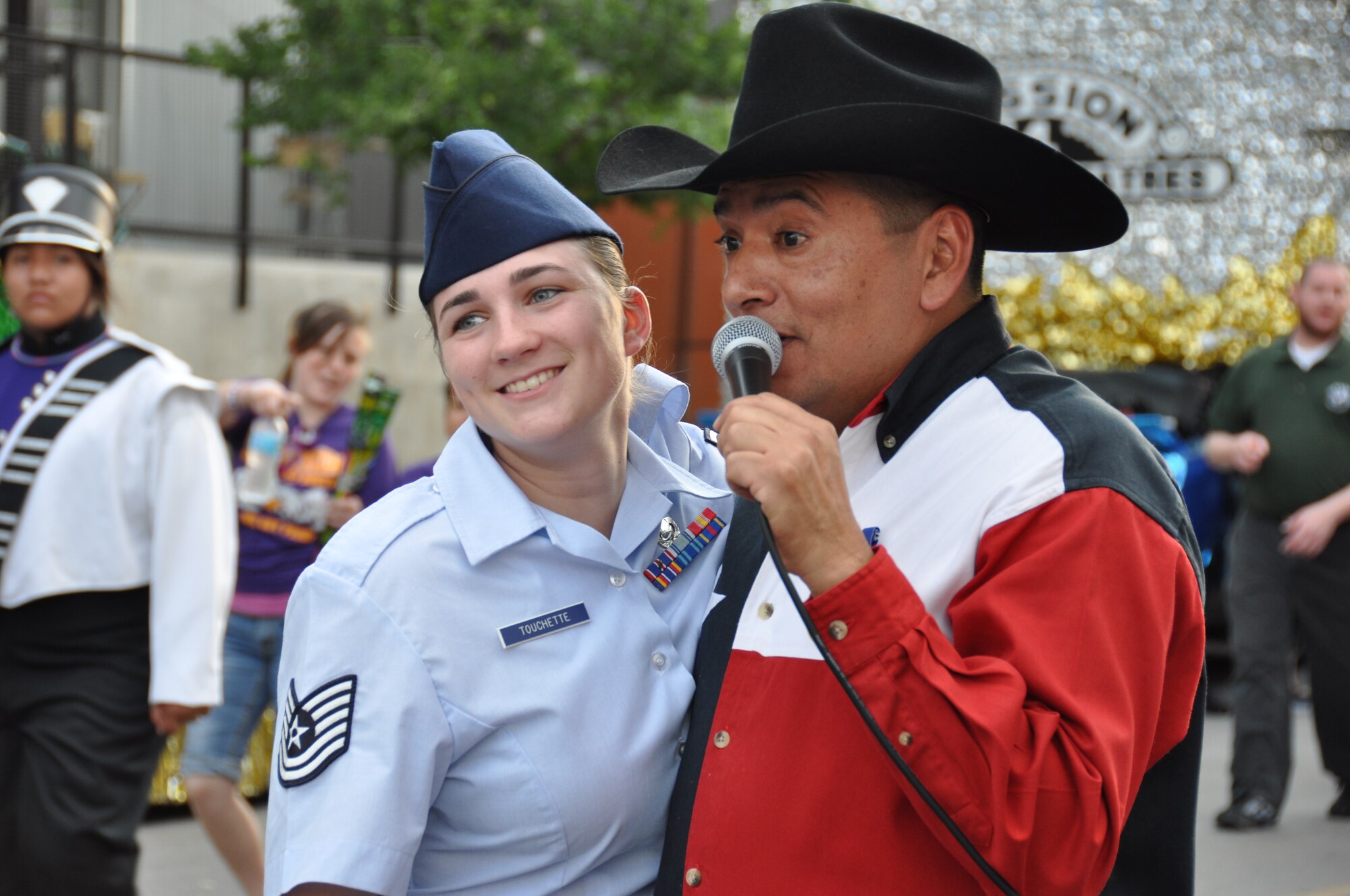 Master Sgt. Max Hernandez, 433rd Maintenance Squadron sings "Looking for Love" during a microphone check to Tech Sgt. Courtney Touchette, 433rd Maintenance Operations Squadron prior to the Fiesta Flambeau Parade. The theme of this year’s parade was "Saturday Night at the Movies." The Alamo Wing decorated its float in tribute to the movie "Urban Cowboy." Over 600,000 spectators packed the streets of San Antonio, April 28, 2012 to witness the event. (U.S. Air Force Photo/Tech. Sgt. Carlos J. Trevino)