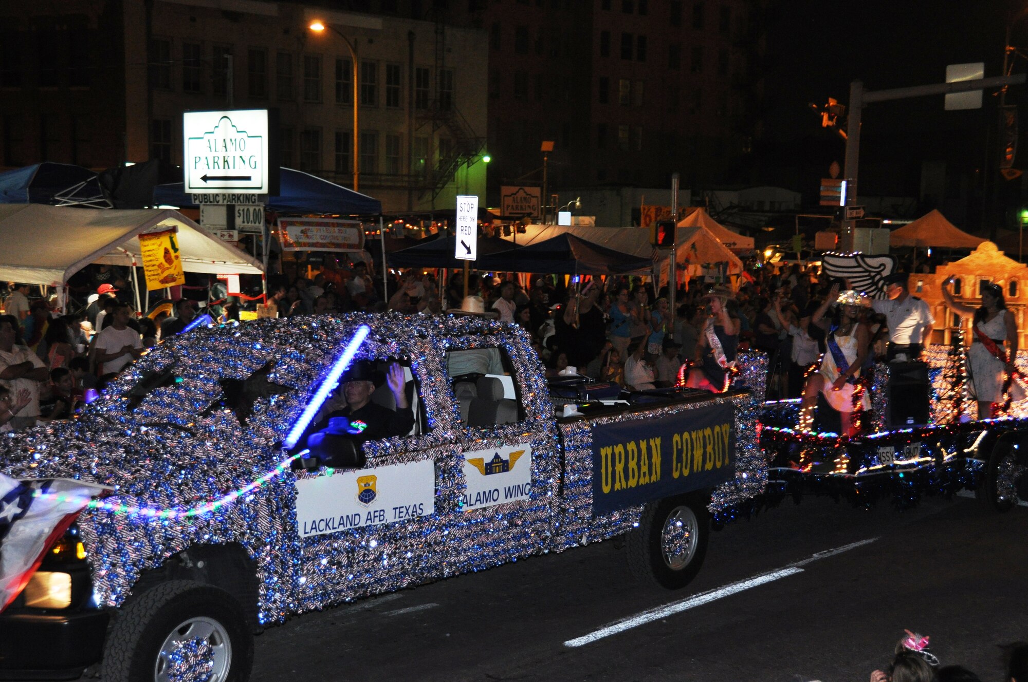 The 433rd Airlift Wing "Urban Cowboy" theme float moves through downtown San Antonio's streets during the Flambeau Parade in San Antonio, April 28, 2012. The parade's theme was "Saturday Night at the Movies," and according to the Fiesta San Antonio program, is "one of the largest illuminated parades in the United States." Over 600,000 spectators lined the streets of San Antonio on a breezy spring evening to see over 200 floats and marching bands perform in the grand finale of Fiesta Week. It is estimated a television and World Wide Web viewing audience of 1.5 million watched this year's parade. (U.S. Air Force Photo/ Tech. Sgt. Carlos J. Trevino)