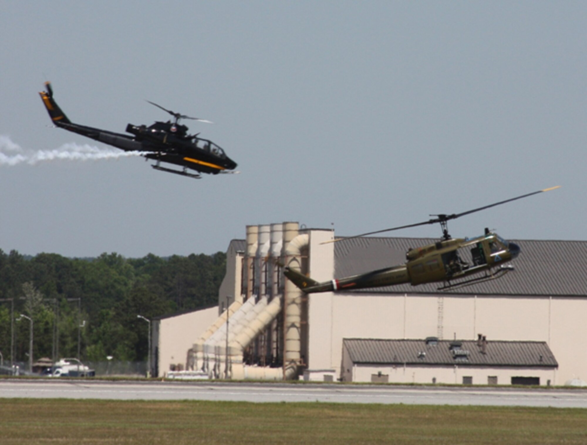 Cobra attack helicopter provide top cover for Huey in re-enacted personnel recovery mission at the Robins Air Show. (U.S. Air Force photo by Senior Airman John Adams)