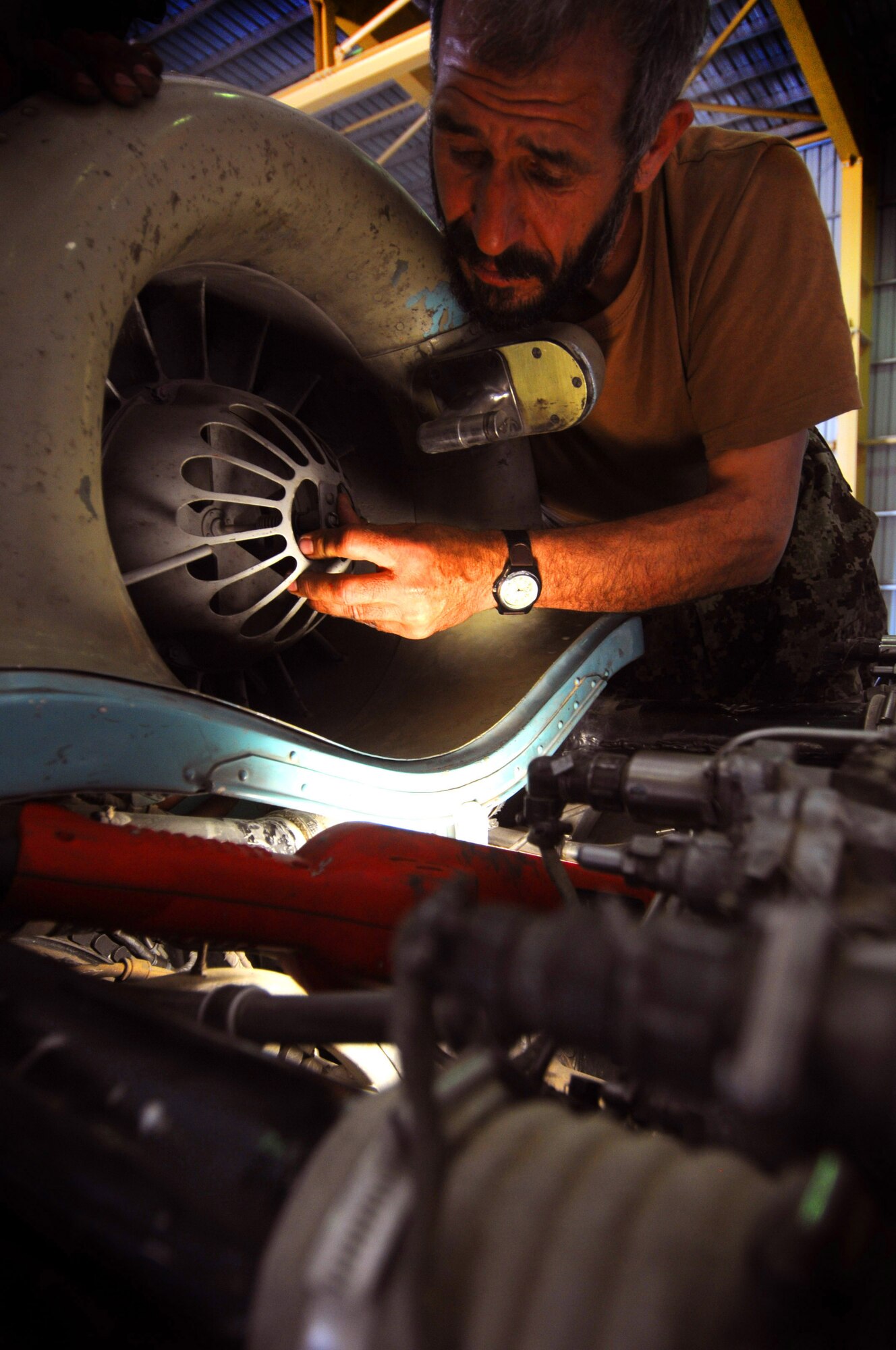Afghan air force Maj. Seiful Malook, acting deputy officer for the AAF Kandahar Air Wing, removes an oil cooling fan from an Afghan Mi-17 Helicopter, Kandahar Air Base, Afghanistan, April 17, 2012. Malook is performing the preventative maintenance as part of a scheduled 1500 hour flight time component change under the supervision of the 442nd Air Expeditionary Advisory Squadron. (U.S. Air Force photo by Staff Sgt. Nadine Y. Barclay)