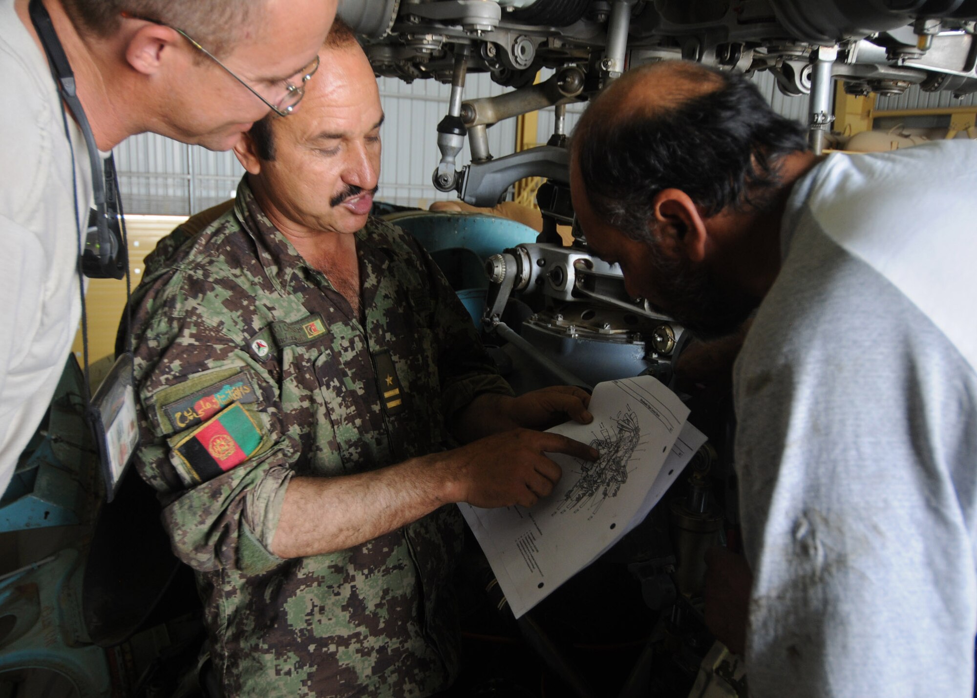 Master Sgt. James Ashcom, an intermediate maintenance section or system advisor with the 442nd Air Expeditionary Advisory Squadron, oversees an on-the-job training session between Afghan air force maintenance personnel at Kandahar Air Base, Afghanistan, April 17, 2012. Ashcom is supervising the AAF while they perform a scheduled 1500 hour flight time component change. (U.S. Air Force photo by Staff Sgt. Nadine Y. Barclay)