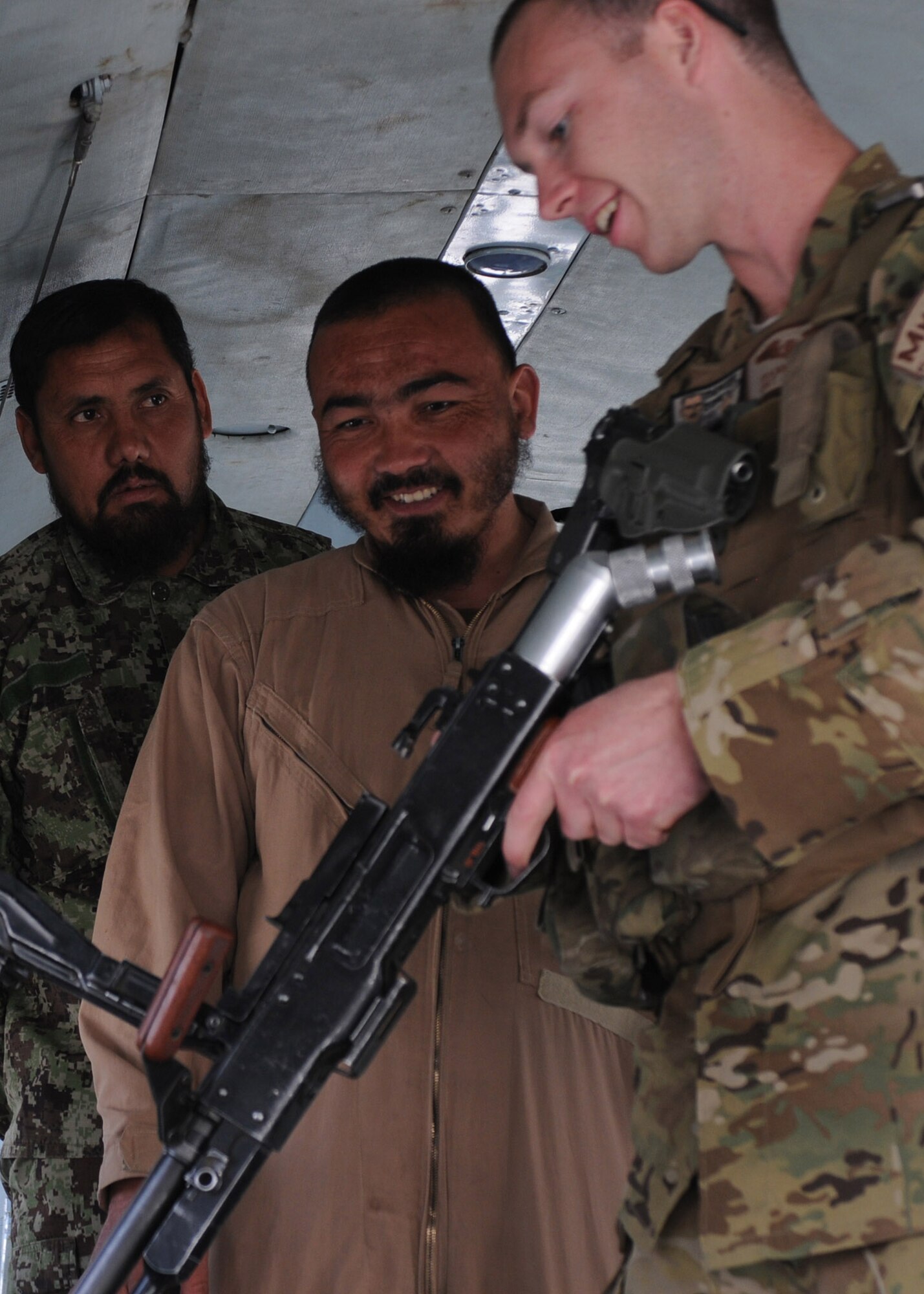 Staff Sgt. Frank Reddy, a 441st Air Expeditionary Advisory Squadron flight engineer, explains the function check process for a Russian PKM machine gun to Afghan air force Mi-17 aircrew personnel prior to a training flight at Kandahar Air Base, Afghanistan, April 17, 2012. Reddy is deployed to Kandahar in support of the NATO Training Mission Afghanistan. (U.S. Air Force photo by Staff Sgt. Nadine Y. Barclay)
