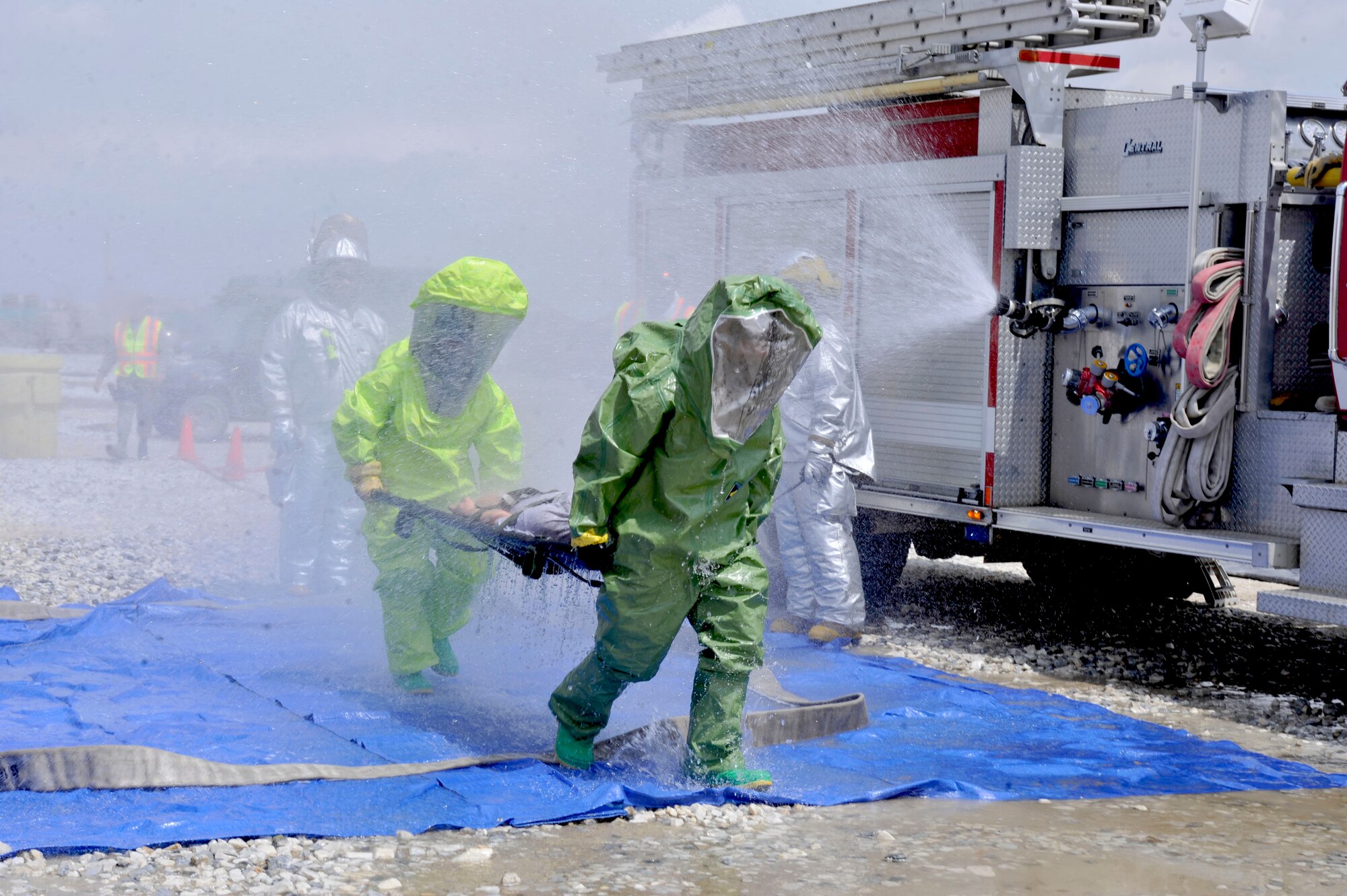 Senior Airman Edward Toscano and Staff Sgt. Cully Ruiz, 455th Emergency Management Flight, carry a simulated victim through detoxification during the Bagram Joint Response Exercise at Bagram Airfield, Afghanistan, April 26, 2012. The exercise allowed the Bagram Disaster Response Force to test its procedural knowledge during a toxic industrial chemical threat. (U.S. Air Force photo/Airman 1st Class Ericka Engblom)