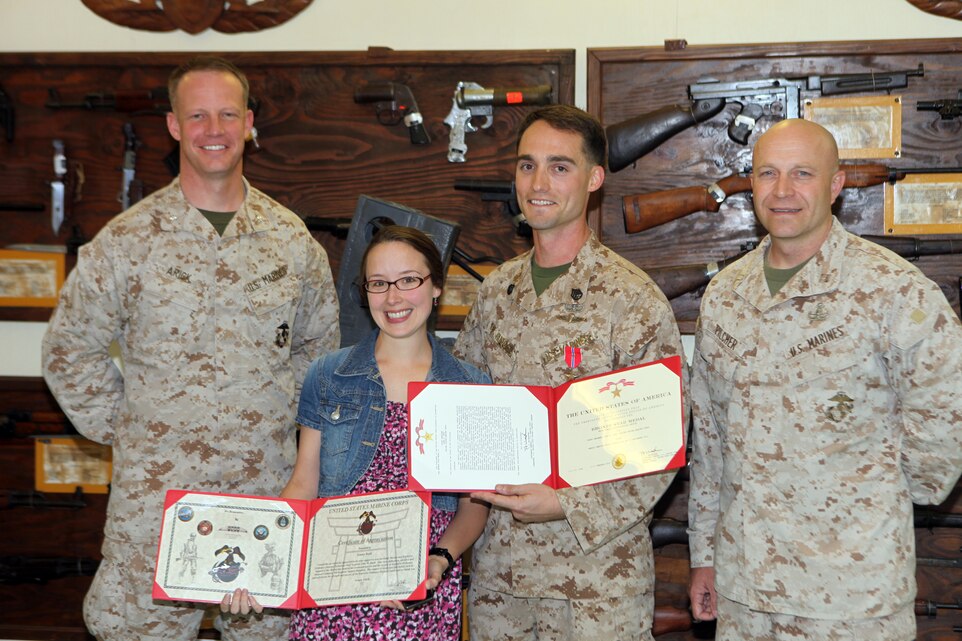 Staff Sgt. John Rudd, an explosive ordinance disposal technician with Combat Logistics Battalion 31, 31st Marine Expeditionary Unit (center right) stands with his wife and Lt Col. William Arick, commanding officer of CLB-31 (left) and Capt. Donald Pilcher, company commander of EOD Company, 9th Engineer Support Battalion, after receiving the Bronze Star with combat distinguishing device here, Apr. 30 for his actions in Afghanistan in 2011 during Operation Enduring Freedom. Rudd earned the medal for both disarming an improvised explosive device under fire and saving a local child's life.