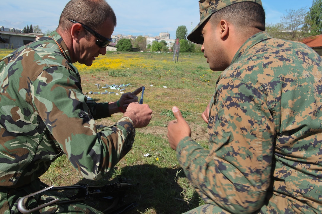 Cpl. Christopher Robert-trinidad, a landing support specialist and assistant non-lethal weapons instructor with Military Police Detachment, Black Sea Rotational Force 12, converses with a Bulgarian special forces soldier in Plovdiv, Bulgaria, April 16. The training was part of a three-day non-lethal weapons display which included kinetic as well as static displays of weapons, equipment and tactics. ::r::::n::