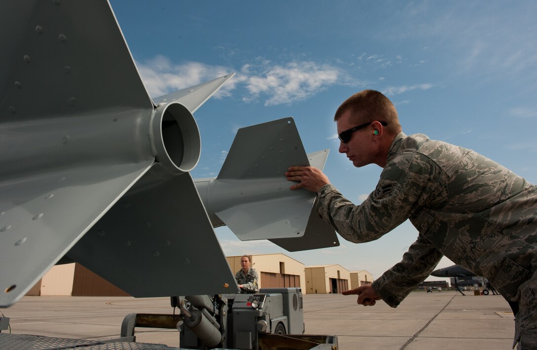 Airman 1st Class Eric Willey, 28th Aircraft Maintenance Squadron weapons load-crew member, directs Airman 1st Class Kesha Denny, 28th AMXS weapons load-crew member, to carefully place a BD-56 bomb onto an MHU 110 munitions trailer after unloading it from a B-1 on the flightline at Ellsworth Air Force Base, S.D., April 26, 2012. Precision is important when handling and transporting explosives to ensure safe and efficient transportation. (U.S. Air Force photo by Airman 1st Class Kate Thornton/Released)