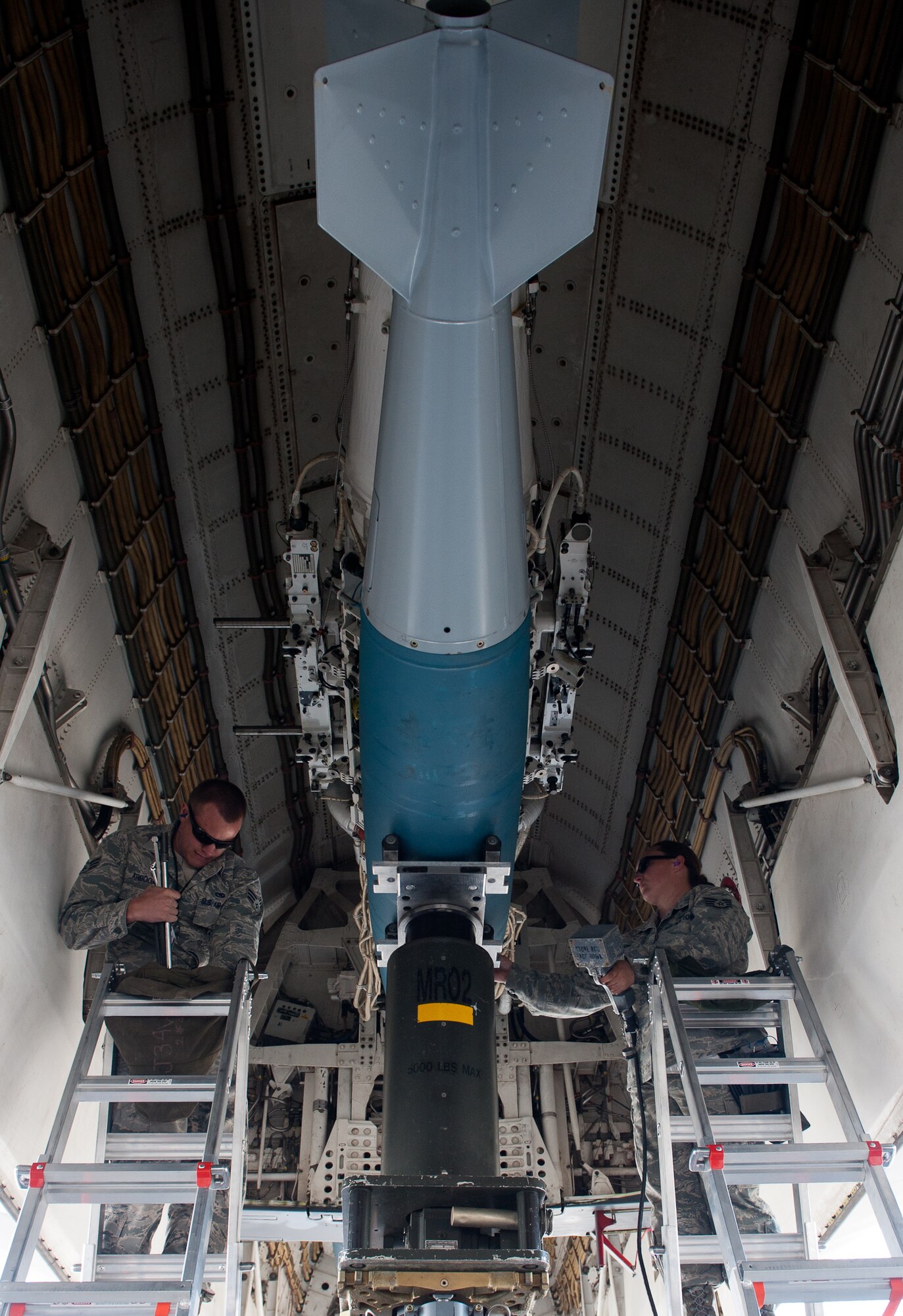 Senior Airman Brian Arbogast (left) and SSgt Nicole Tauzin, 28th Aircraft Maintenance Squadron weapons load-crew, prepare to unload a BD-56 bomb from a B-1 on the flightline at Ellsworth Air Force Base, S.D., April 26, 2012. The weapons flight is responsible for loading munitions in preparation for flying. (U.S. Air Force photo by Airman 1st Class Kate Thornton/Released)