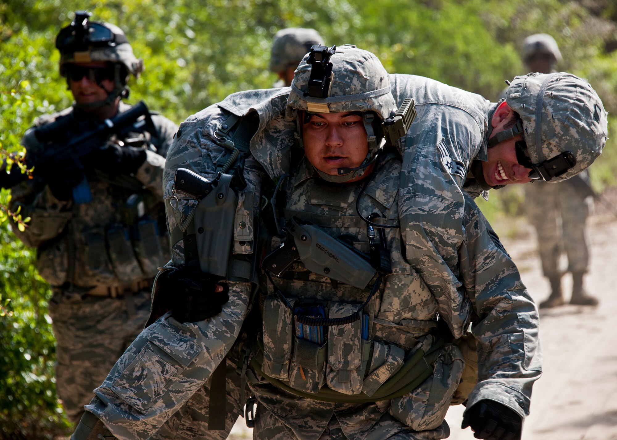 Staff Sgt. Andres Cabral, carries Senior Airman Travis Turner, of the 49th Security Forces Squadron, back to camp after Turner was wounded in a simulated firefight while on patrol at the three-day Brave Defender field training exercise April 27 at Eglin Air Force Base, Fla.  The exercise is the culmination of Air Force Materiel Command’s six-week security forces deployment training, administered by the 96th Ground Combat Training Squadron. GCTS instructors teach 10 training classes a year, which consists of improvised explosive device detection and reaction, operating in an urban environment, mission planning, land navigation, casualty care and more. More than 100 active-duty and National Guard Airmen attended this training. (U.S. Air Force photo/Samuel King Jr.)