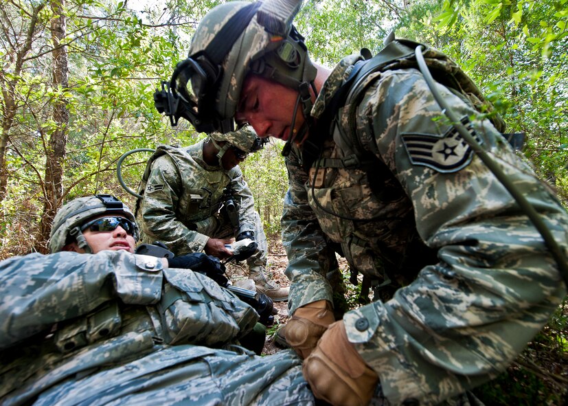 Staff Sgt. Justin Goad, of the 49th Security Forces Squadron, places a tourniquet on a simulated victim of an attack while on patrol during the three-day Brave Defender field training exercise April 27 at Eglin Air Force Base, Fla.  The exercise is the culmination of Air Force Materiel Command’s six-week security forces deployment training, administered by the 96th Ground Combat Training Squadron. GCTS instructors teach 10 training classes a year, which consists of improvised explosive device detection and reaction, operating in an urban environment, mission planning, land navigation, casualty care and more. More than 100 active-duty and National Guard Airmen attended this training. (U.S. Air Force photo/Samuel King Jr.)
