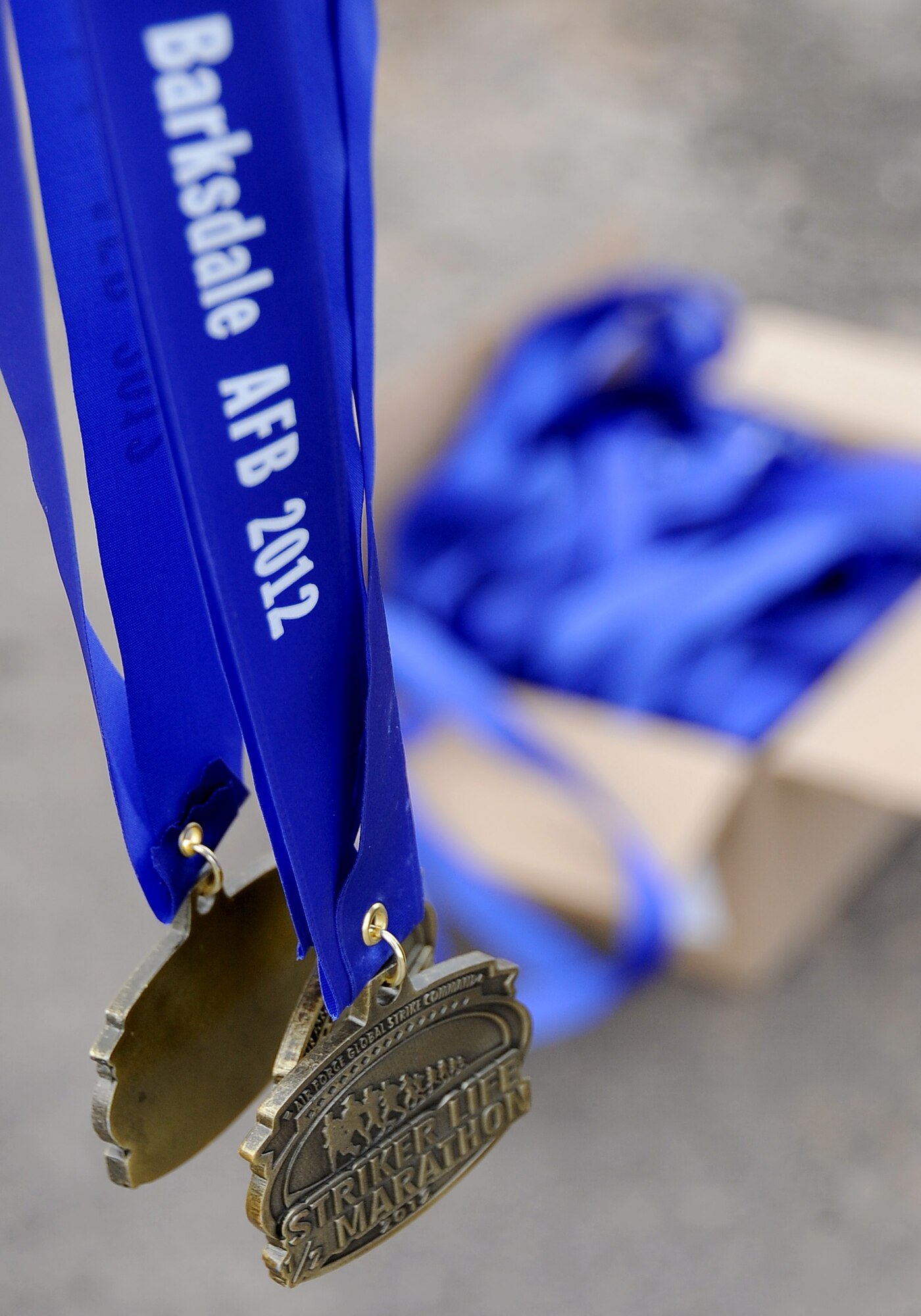 Medals sit near the finish line in preparation to be handed out to Team Barksdale members participating in the Air Force Global Strike Command Striker Life Half Marathon on Barksdale Air Force Base, La., April 28. More than 150 participants were given a commemorative t-shirt and medal along with their bib number prior to the start of the first-ever half marathon held by the command. (U.S. Air Force photo/Staff Sgt. Amber Ashcraft)(RELEASED)