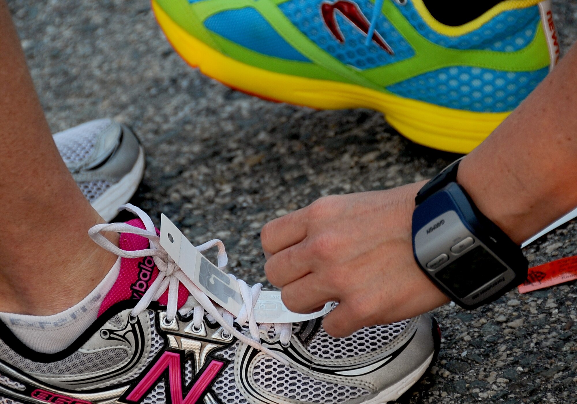 A marathon participant helps another runner attach a chip to her shoe prior to the start of the Air Force Global Strike Command Striker Life Half Marathon on Barksdale Air Force Base, La., April 28. The chips and timing devices were provided by No Limits Timing of Shreveport, La., to keep track of the times of each of the 150 marathon participants. (U.S. Air Force photo/Staff Sgt. Amber Ashcraft)(RELEASED)