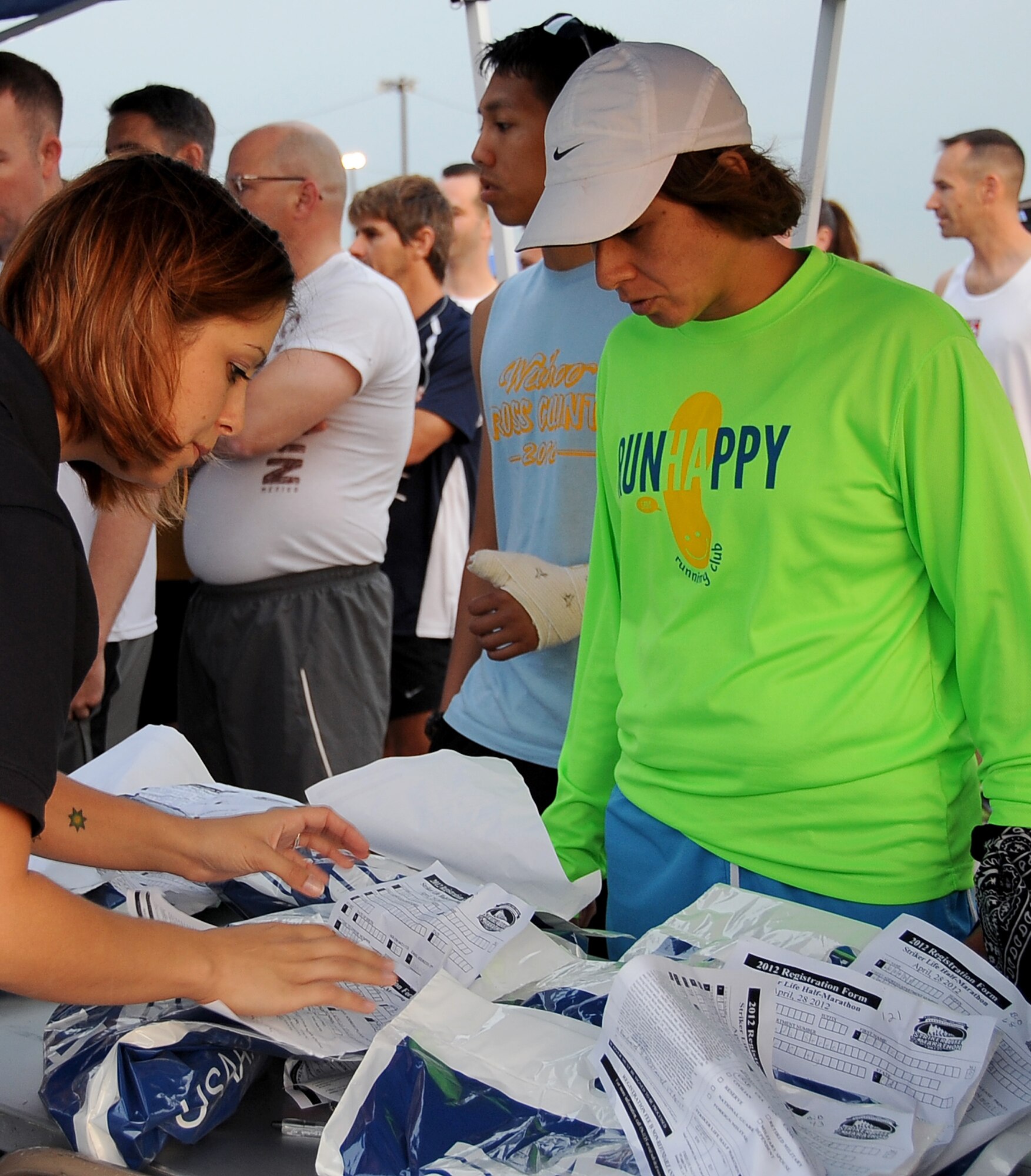 A 2nd Force Support Squadron Airman helps a marathon participant locate her bib information prior to the start of the Air Force Global Strike Command Striker Life Half Marathon on Barksdale Air Force Base, La., April 28. More than 150 participants were given a commemorative t-shirt and medal along with their bib number prior to the start of the first-ever half marathon held by the command. (U.S. Air Force photo/Staff Sgt. Amber Ashcraft)(RELEASED)