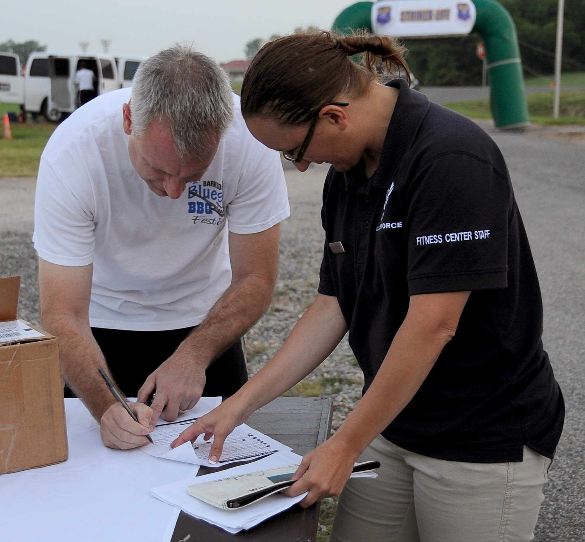 Col. Tim Fay, 2nd Bomb Wing commander, fills out information to receive his bib number prior to the start of the Air Force Global Strike Command Striker Life Half Marathon on Barksdale Air Force Base, La., April 28. More than 150 Team Barksdale members participated in the first-ever event. (U.S. Air Force photo/Staff Sgt. Amber Ashcraft)(RELEASED)