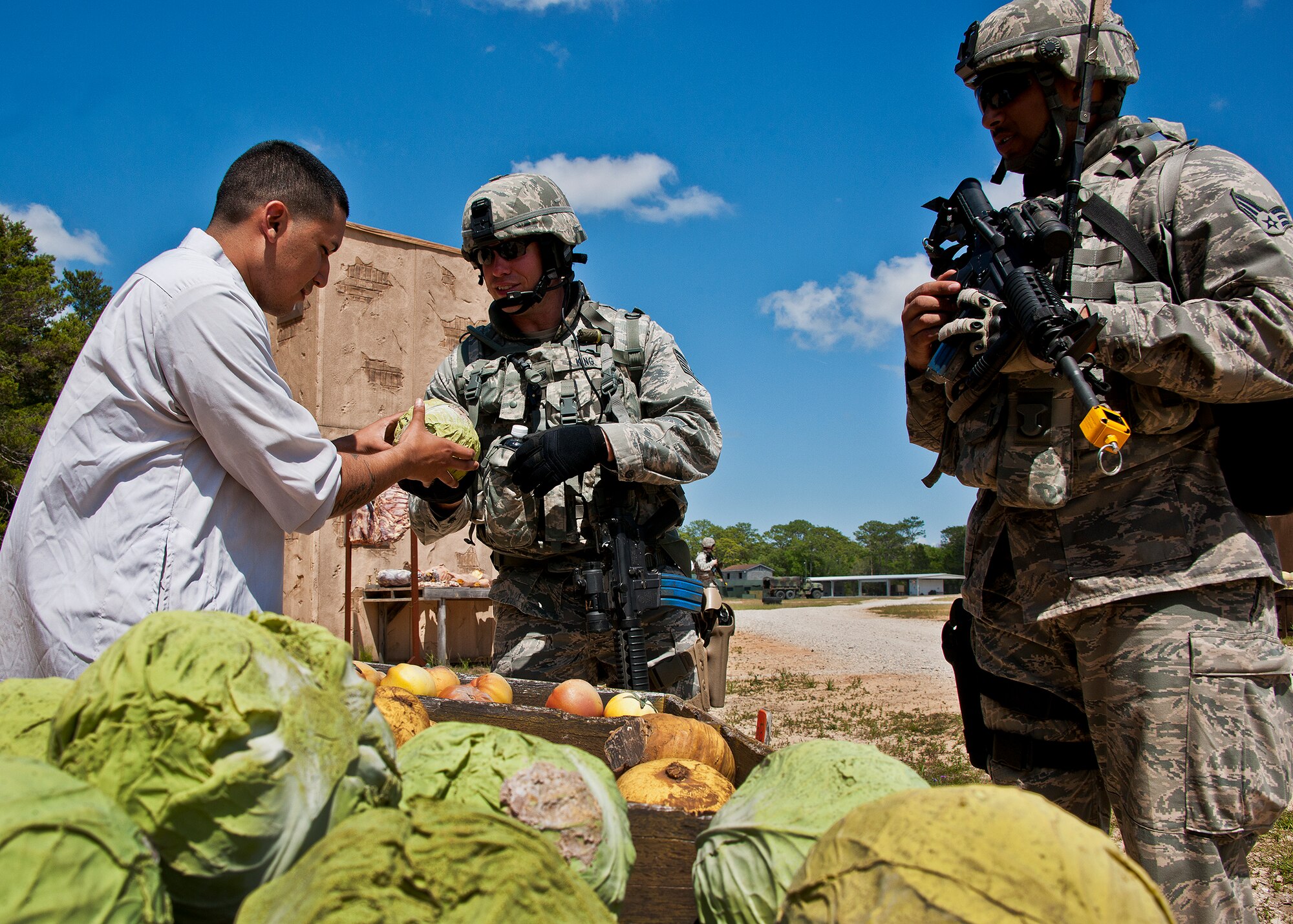 Tech. Sgt. Kristopher King, a guardsman from the 114th Security Forces Squadron, interacts with a villager while on the first dismounted counter-insurgency operation of the three-day Brave Defender field training exercise April 26 at Eglin Air Force Base, Fla.  The exercise is the culmination of Air Force Materiel Command’s six-week security forces deployment training, administered by the 96th Ground Combat Training Squadron. GCTS instructors teach 10 training classes a year, which consists of improvised explosive device detection and reaction, operating in an urban environment, mission planning, land navigation casualty care and more. More than 100 active-duty and National Guard Airmen attended this training. (U.S. Air Force photo/Samuel King Jr.)
