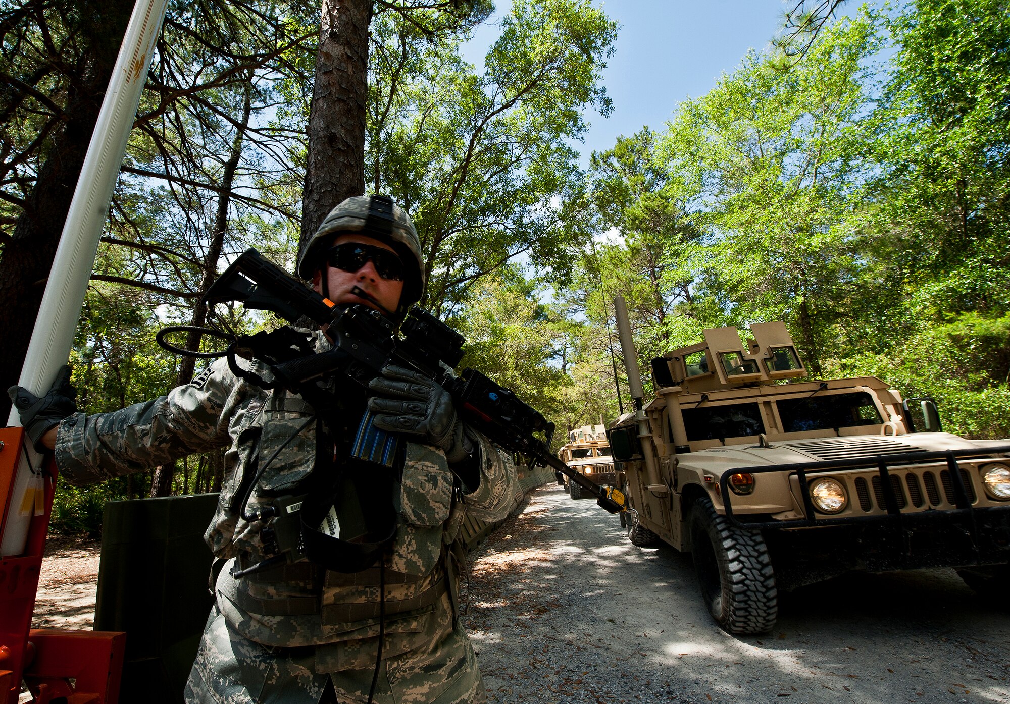 Staff Sgt. Ryan Hushour, from the 22nd Security Forces Squadron, holds the entry control point gate open for the first mounted patrol of the three-day Brave Defender field training exercise April 26 at Eglin Air Force Base, Fla.  The exercise is the culmination of Air Force Materiel Command’s six-week security forces deployment training, administered by the 96th Ground Combat Training Squadron. GCTS instructors teach 10 training classes a year, which consists of improvised explosive device detection and reaction, operating in an urban environment, mission planning, land navigation casualty care and more. More than 100 active-duty and National Guard Airmen attended this training. (U.S. Air Force photo/Samuel King Jr.)




