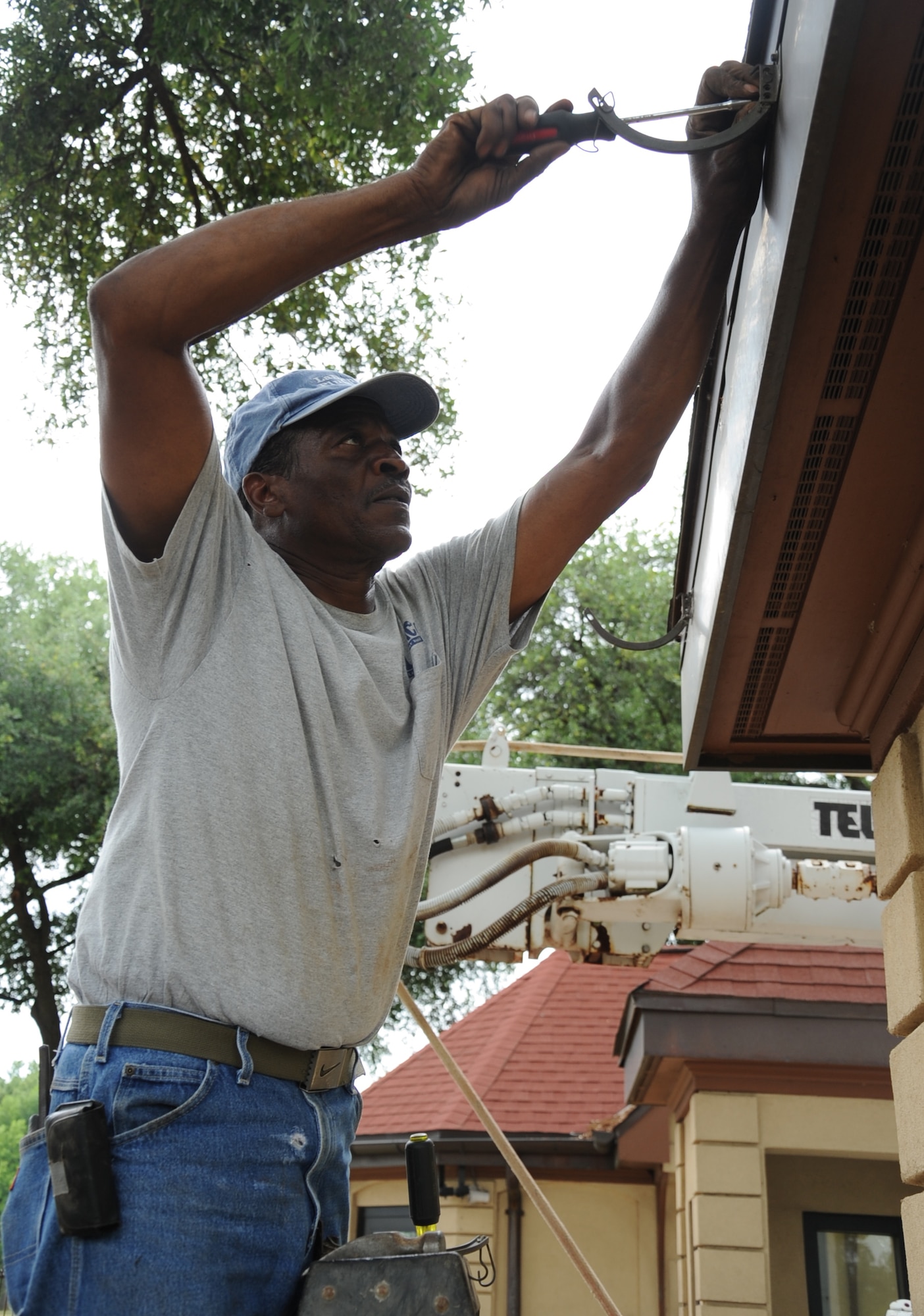 Marvin Lewis, local construction worker, removes a hook from a guard shack during a construction project at the West Gate on Barksdale Air Force Base, La., April 30. The project is scheduled to last 90 days. An overhang will be installed to provide shade for 2nd Security Forces Squadron personnel assigned to the gate. (U.S. Air Force photo/Senior Airman Sean Martin)(RELEASED)

