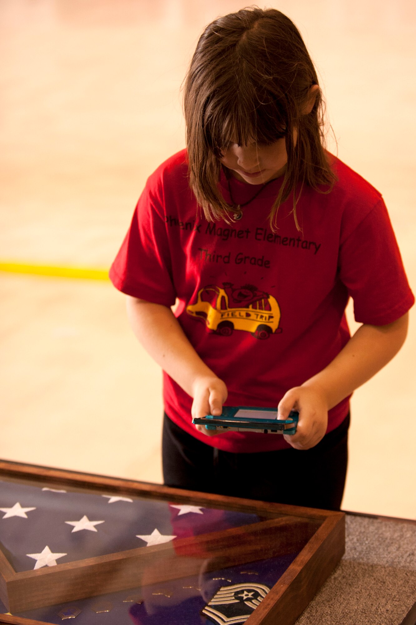 A Phoenix Magnet Elementary School student takes a picture of a shadow box presented to her teacher, Senior Master Sgt. Margaret Maffett, 917th Aircraft Maintenance Squadron first sergeant, during a retirement ceremony at Barksdale Air Force Base, La., April 27, 2012. Maffett retired from the Air Force Reserve after more than 30 years of service. (U.S. Air Force photo by Master Sgt. Greg Steele/Released)