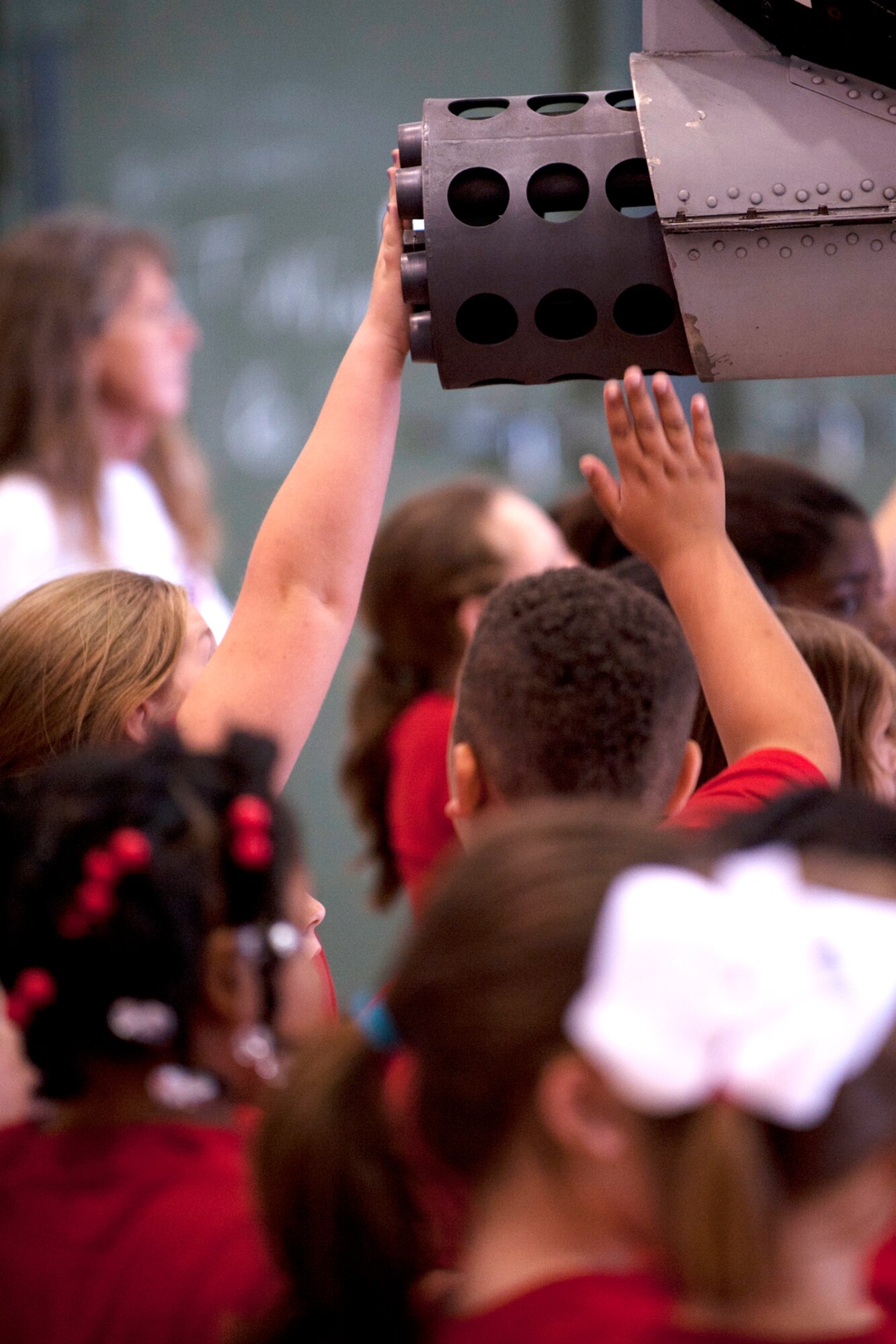 Students from the Phoenix Magnet Elementary School from Alexandria, La., reach up to touch the muzzle of a 917th Fighter Group A-10 Thunderbolt II during a tour at Barksdale Air Force Base, La., April 27, 2012. The students supported members of the 917th Fighter Group during their recent deployment to Afghanistan by sending letters and care packages. (U.S. Air Force photo by Master Sgt. Greg Steele/Released)