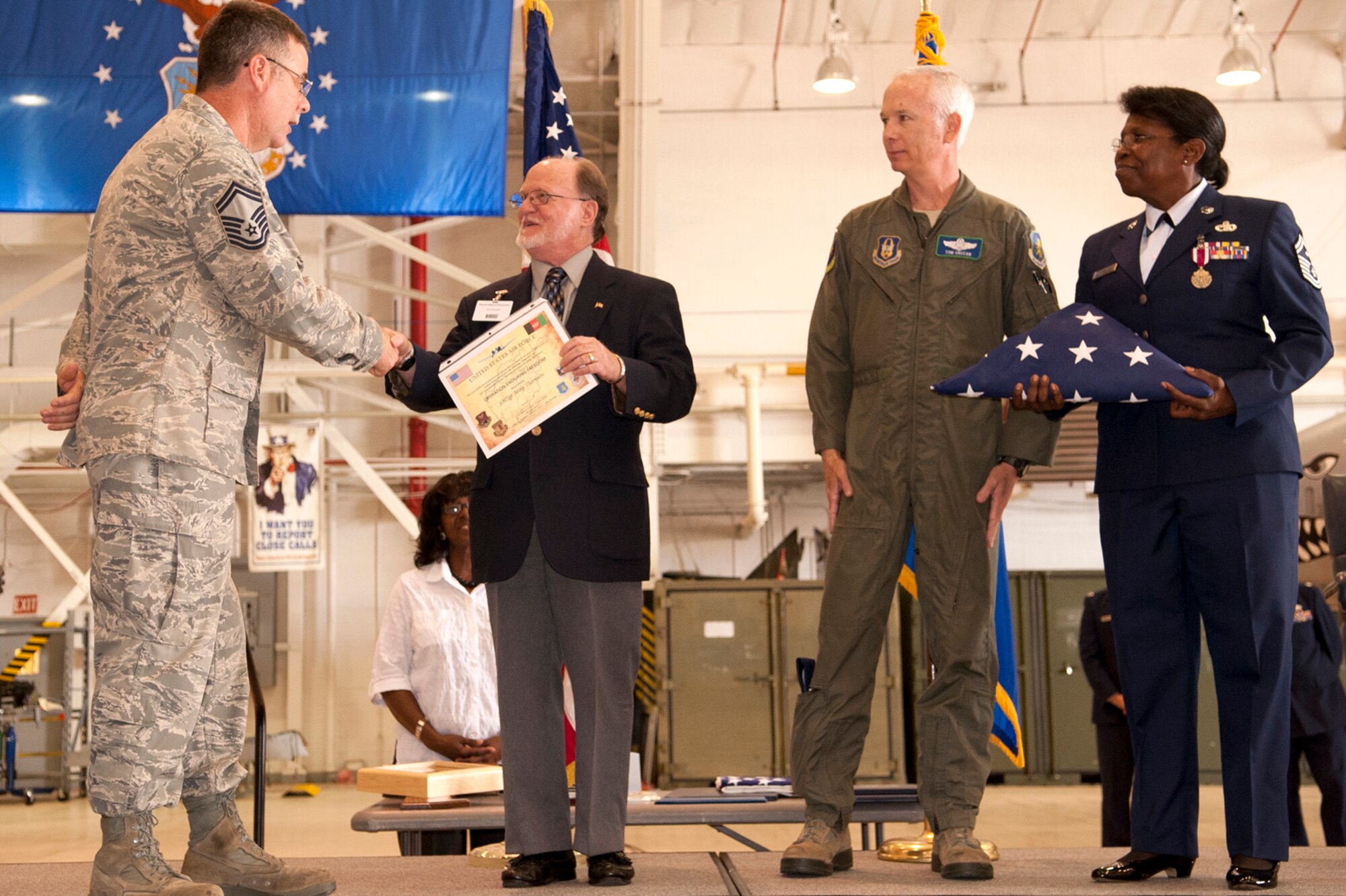 U.S. Air Force Senior Master Sgt. Mike Thornton, 917th Aircraft Maintenance Squadron production superintendent, presents a certificate and American flag, which was flown on a 917th Fighter Group A-10 Thunderbolt II over Afghanistan, to a faculty member from the Phoenix Magnet Elementary School, during a retirement ceremony for Senior Master Sgt. Margaret Maffett, Barksdale Air Force Base, La., April 27, 2012. Phoenix Magnet students supported the 917th Fighter Group during their recent deployment to Afghanistan by sending care and letters to the troops. (U.S. Air Force photo by Master Sgt. Greg Steele/Released)