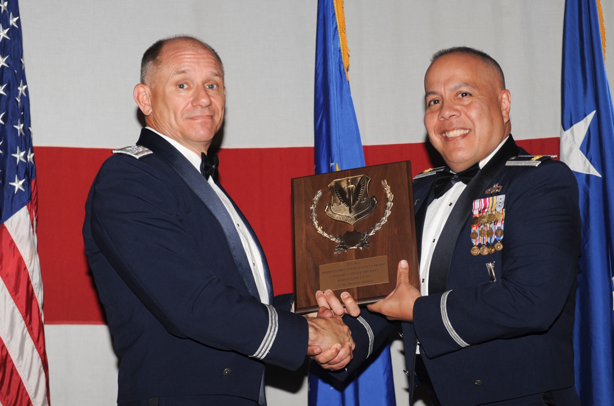 (Left) U.S. Air Force Maj. Gen. Mark Atkinson, Air Combat Command director of logistics, presents the Air Combat Command maintenance effectiveness award in the small category to Maj. Dennis Higuera, 23d Component Maintenance Squadron commander, during the 2011 Maintenance Professional of the Year banquet at the James H. Rainwater Conference Center in Valdosta, Ga., April 26, 2012. The 23d CMS worked as a team and was named best in the small arms category in 2011. (U.S. Air Force photo by Airman 1st Class Douglas Ellis/Released)