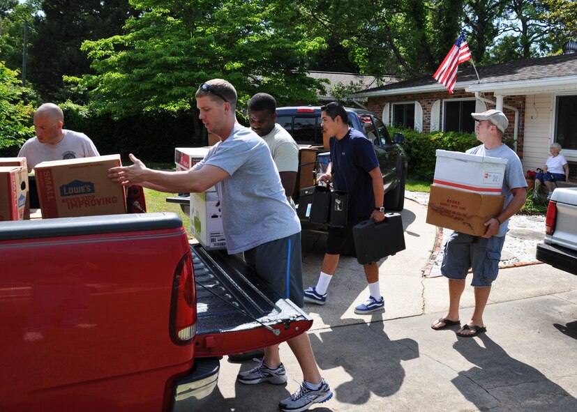 Airmen from Eglin Air Force Base and Duke Field move boxes of household items onto awaiting pickup trucks outside the home of Lucy Harstvedt (seated, far right) in Shalimar, Fla., April 20, 2012.  Eight Airmen responded to a call for volunteers to help Harstvedt, an Air Force widow since 1964, relocate to the nearby Bob Hope Village since she was unable to conduct the move. Bob Hope Village, a retirement home for surviving spouses of Air Force enlisted members, is part of the overall non-profit Air Force Enlisted Village. (U.S. Air Force photo/Dan Neely)