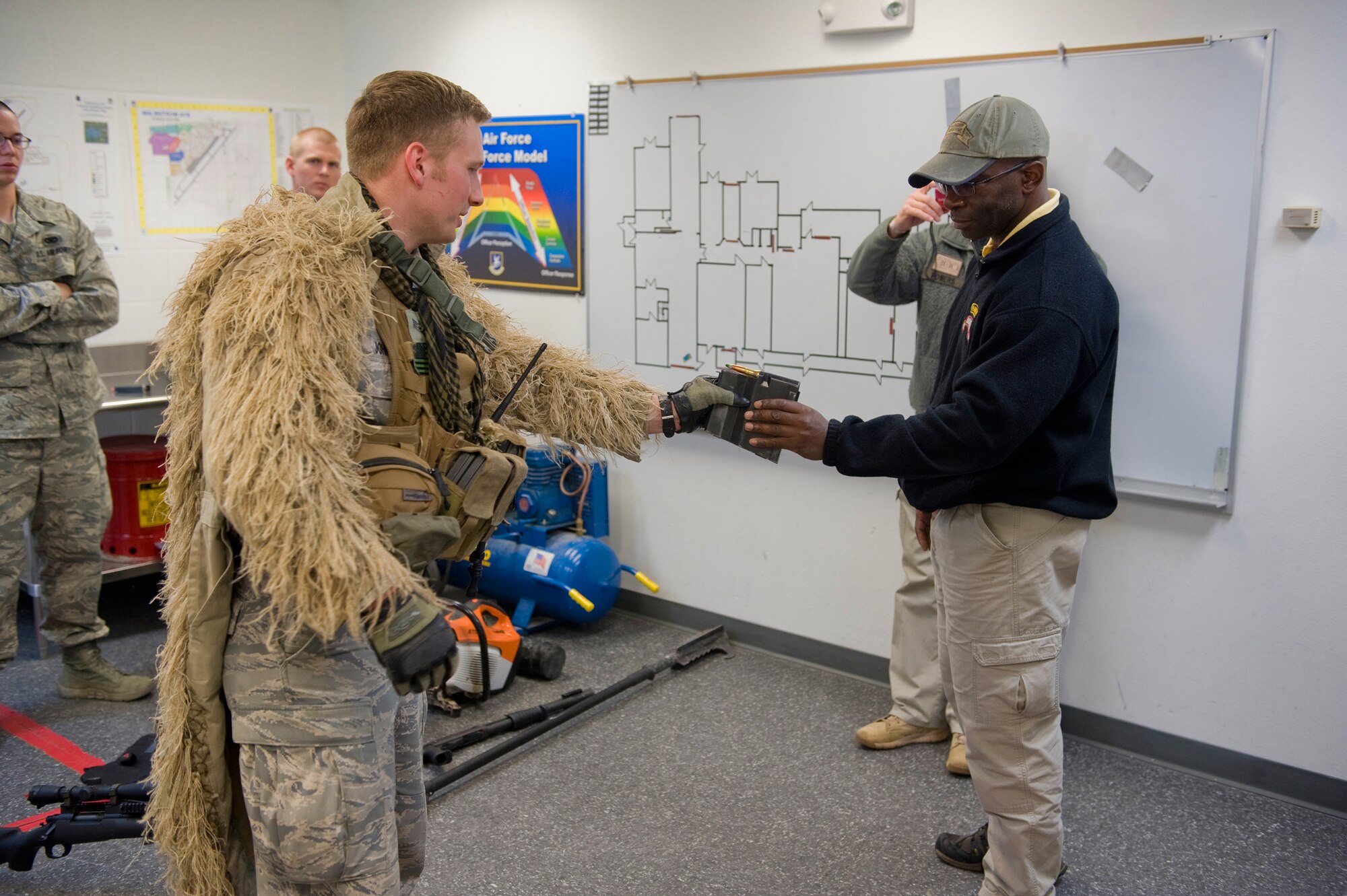 Staff Sgt. Hubert Johns, 341st Security Forces Group advanced designated marksman, shows Mullen 50 caliber ammunition during Mullen's visit to the TRF facility through the American300 Warrior Tours, April 18. During his tour, Mullen also toured a few Missile Alert Facilities, the Weapons Storage Area, Missile Security Control and the 741st Missile Security Forces Squadron dispatch. (U.S. Air Force photo/Beau Wade)
