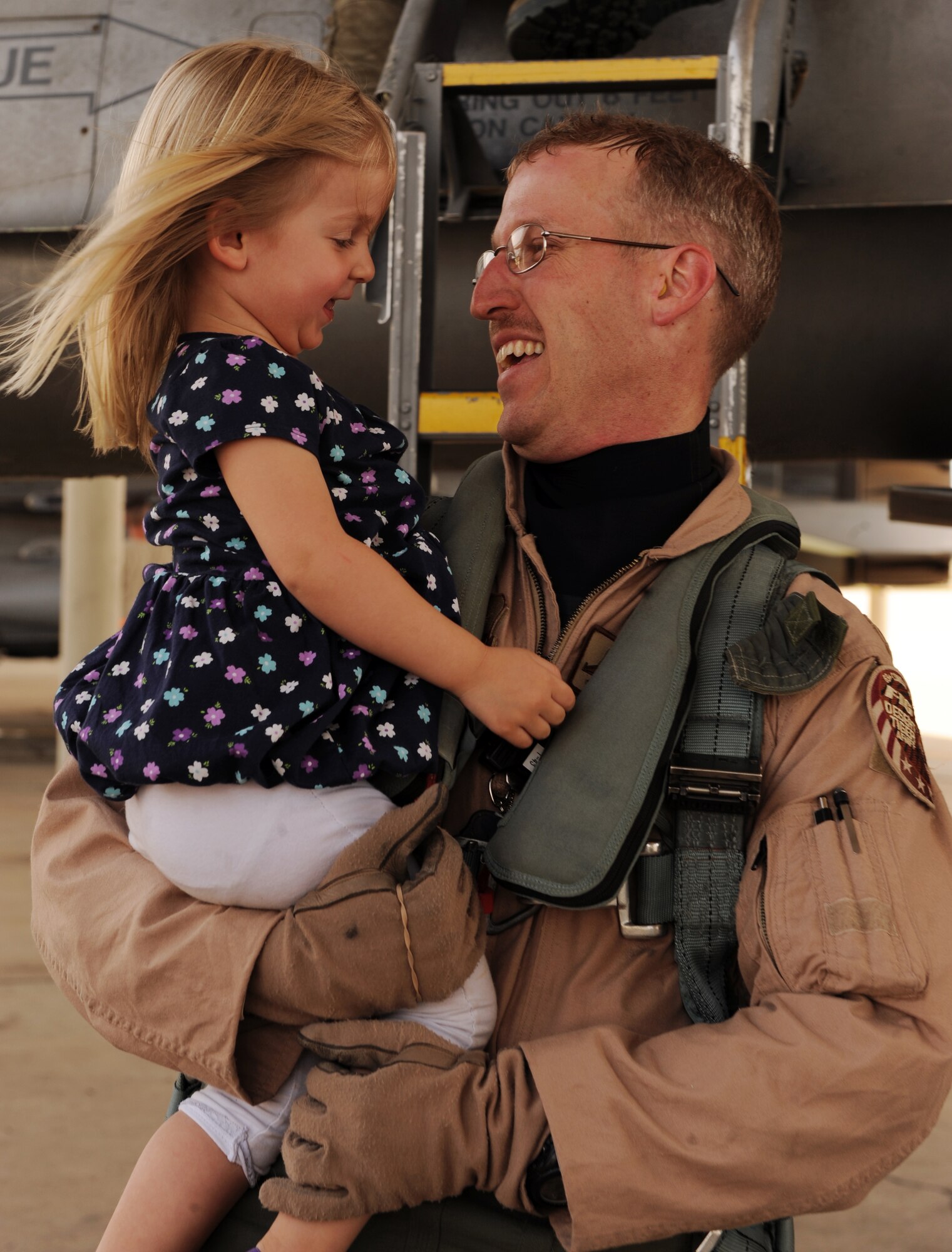 U.S. Air Force Maj. Andy Pitts, 79th Fighter Squadron F-16 Fighting Falcon pilot, holds his daughter Madeline Pitts after returning home to Shaw Air Force Base, S.C., April 25, 2012. The 79th FS returned home after a seven-month deployment to Iraq, where they provided top cover for the last convoys to leave Iraq. (U.S. Air Force photo by Senior Airman Tabatha McCarthy/released)