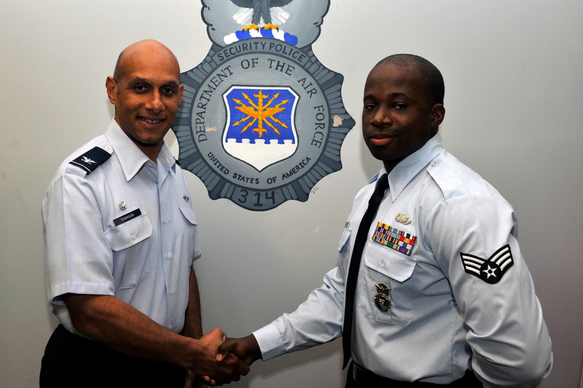 Col. Brian Robinson, 19th Airlift Wing commander, presents a commander's coin to Senior Airman William Hairston, a 19th Security Forces Squadron security response team leader, April 23, 2012, at Little Rock Air Force Base, Ark. Hairston, an Oxon Hill, Md. native, was awarded for ensuring only authorized personnel gain access to the installation. (U.S. Air Force photo by Airman 1st Class Rusty Frank)

