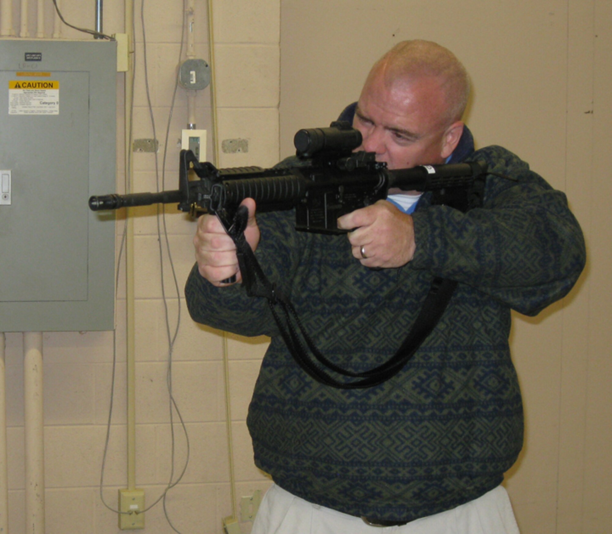 GRISSOM AIR RESERVE BASE, Ind., -- Mr. Leilan McNally, honorary 434th Maintenance Group commander, aims his weapon at the target during a visit to the Security Forces combat arms training simulator. (U.S. Air Force photo/Lt. Col. Gary Lockard)                              
