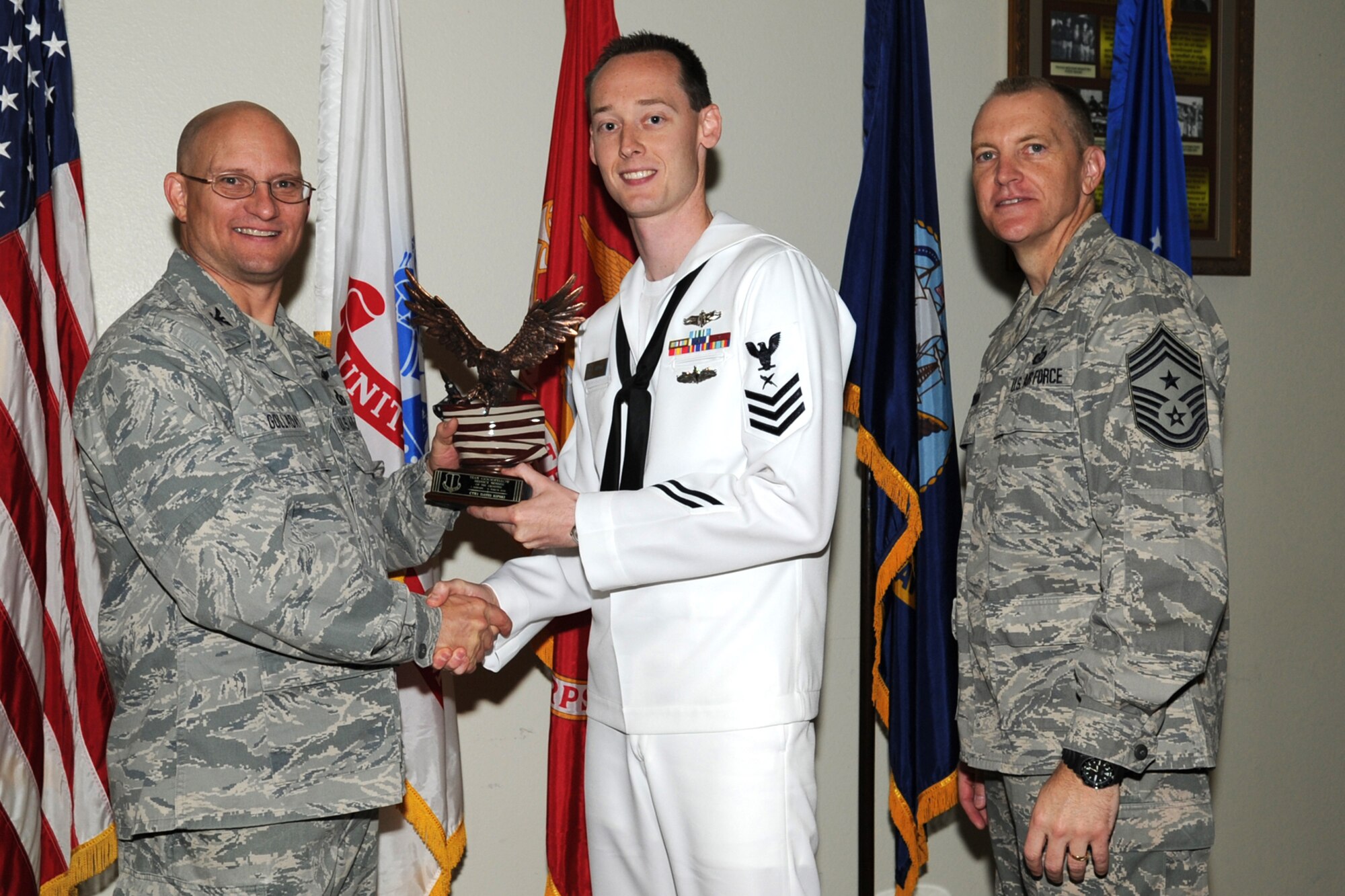 GOODFELLOW AIR FORCE BASE, Texas -- Col. William Golladay, 17th Training Wing Vice Commander, and Chief Master Sgt. Scott Lumpkin, 17th TRW Command Chief, present the Team Goodfellow Servicemember of the Quarter award to Navy Petty Officer 1st Class David Ripski, Center for Information Dominance Detachment, during the wing quarterly awards ceremony April 24. (U.S. Air Force photo/Staff Sgt. Laura R. McFarlane)
