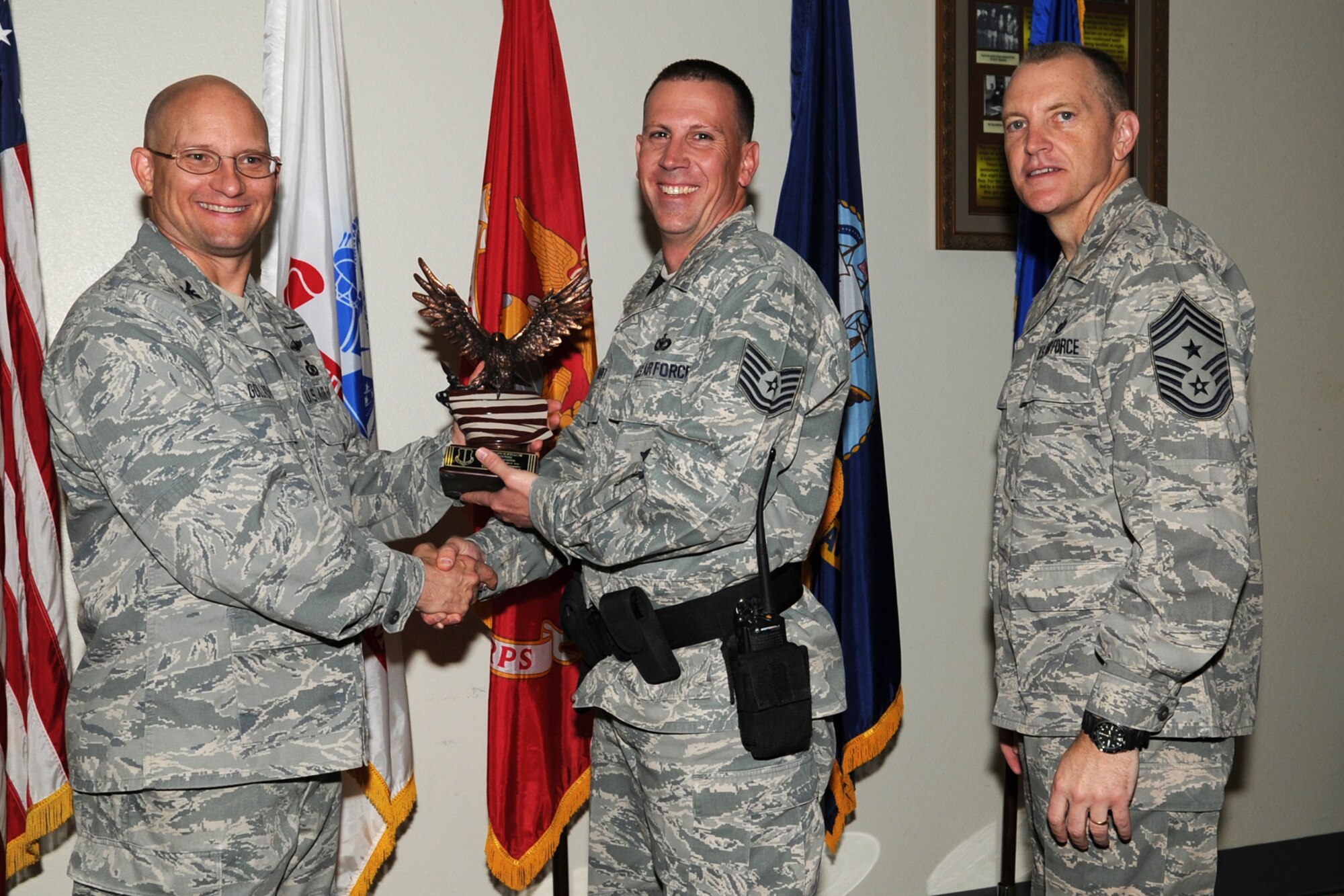 GOODFELLOW AIR FORCE BASE, Texas -- Col. William Golladay, 17th Training Wing Vice Commander, and Chief Master Sgt. Scott Lumpkin, 17th TRW Command Chief, present the Team Goodfellow Volunteer of the Quarter award to Tech. Sgt. Richard Bart, 17th Security Forces Squadron, during the wing quarterly awards ceremony April 24. (U.S. Air Force photo/Staff Sgt. Laura R. McFarlane)
