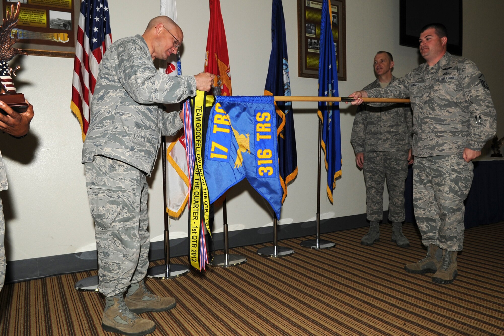 GOODFELLOW AIR FORCE BASE, Texas -- Col. William Golladay, 17th Training Wing Vice Commander, places the Team Goodfellow Unit of the Quarter streamer on the 316th Training Squadron guidon during the wing quarterly awards ceremony April 24. (U.S. Air Force photo/Staff Sgt. Laura R. McFarlane)