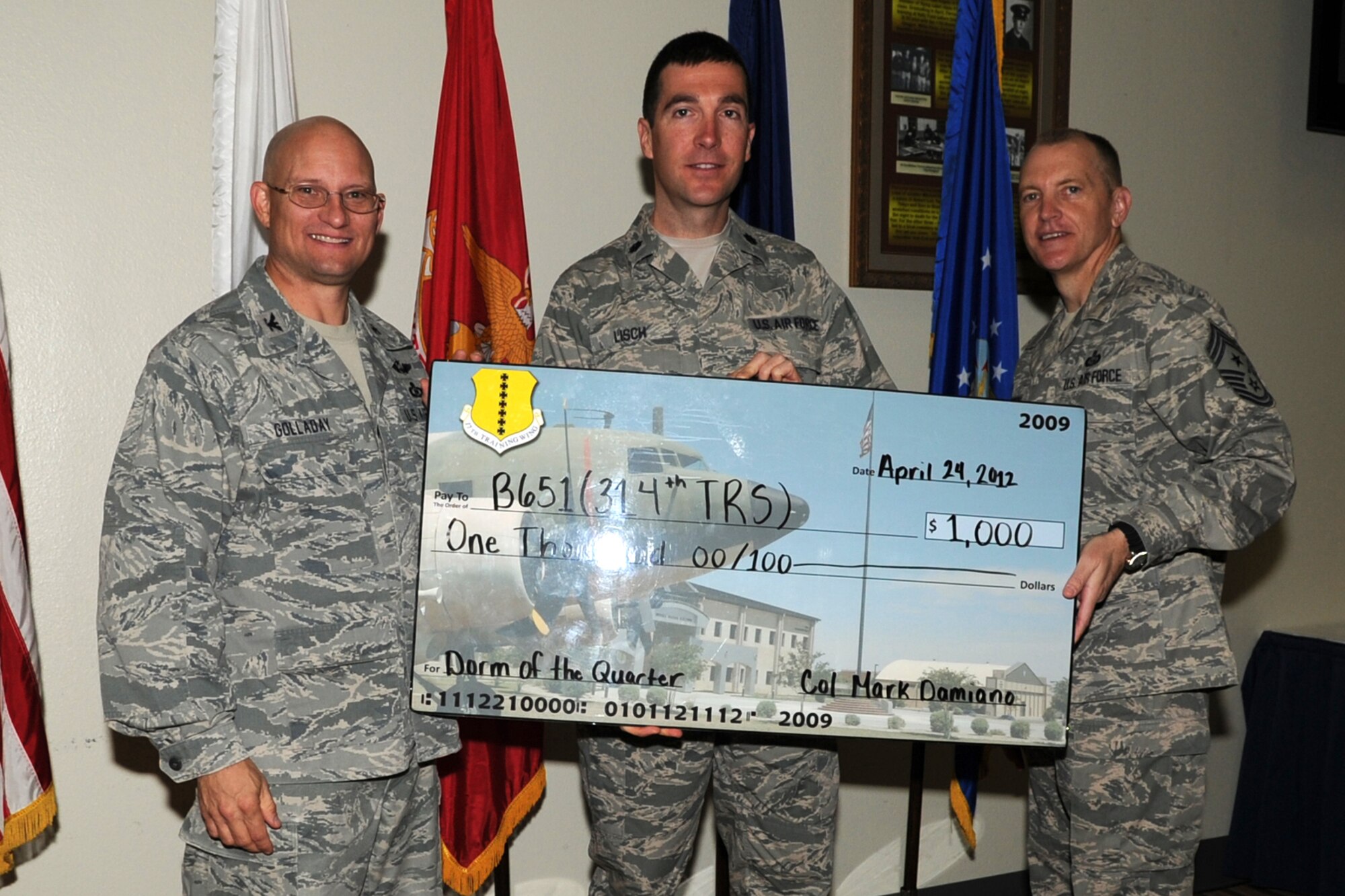GOODFELLOW AIR FORCE BASE, Texas -- Col. William Golladay, 17th Training Wing Vice Commander, and Chief Master Sgt. Scott Lumpkin, 17th TRW Command Chief, present Lt. Col. Robert Lisch, 517th Training Group, with the Team Goodfellow, Presidio of Monterey Dormitory of the Quarter for Dorm B651, 314th Training Squadron, during the wing quarterly awards ceremony April 24. (U.S. Air Force photo/Staff Sgt. Laura R. McFarlane)