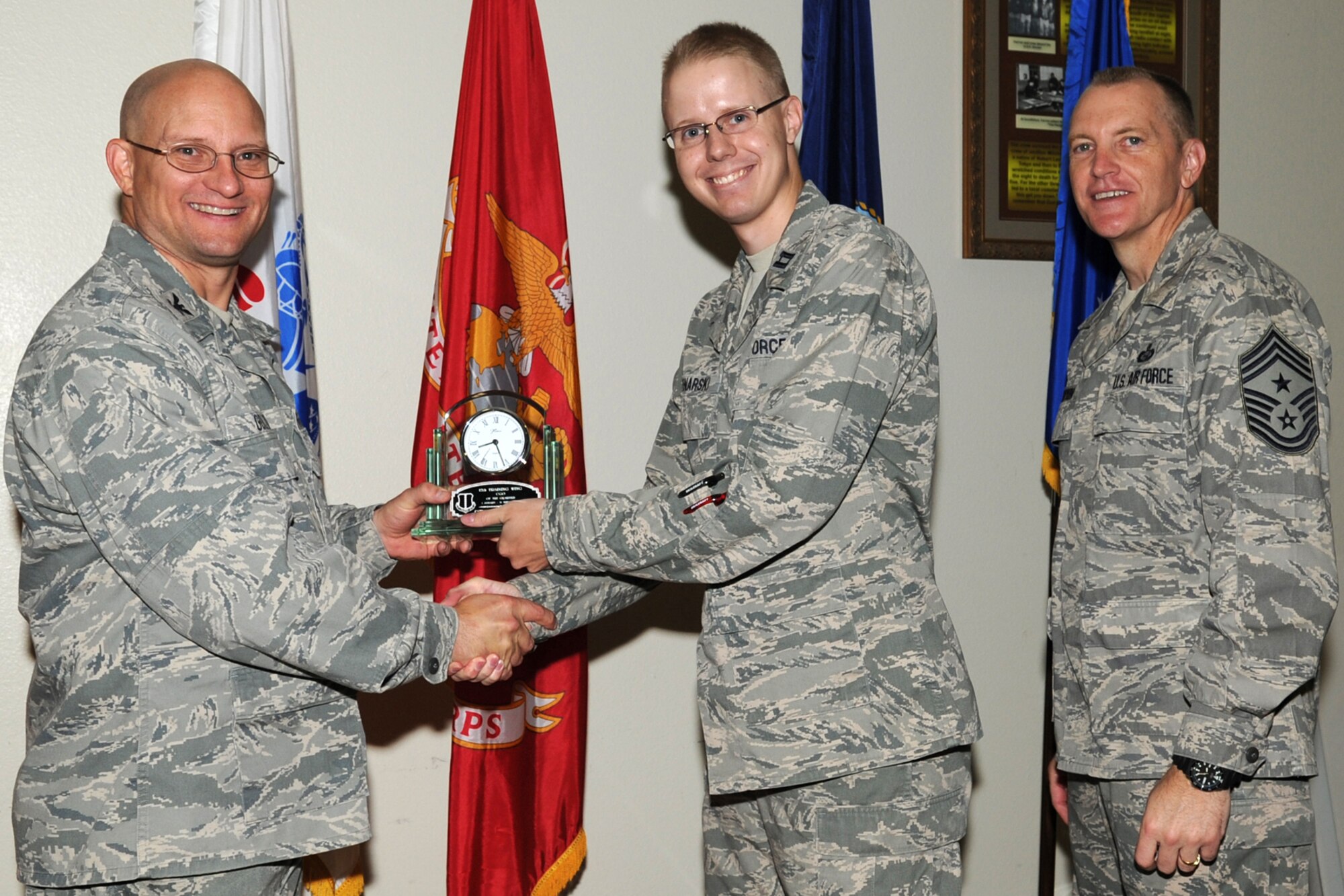 GOODFELLOW AIR FORCE BASE, Texas -- Col. William Golladay, 17th Training Wing Vice Commander, and Chief Master Sgt. Scott Lumpkin, 17th TRW Command Chief, present the 17th Training Wing Company Grade Officer of the Quarter to Capt. Jonathan Swinarski, 315th Training Squadron, during the wing quarterly awards ceremony April 24. (U.S. Air Force photo/Staff Sgt. Laura R. McFarlane)