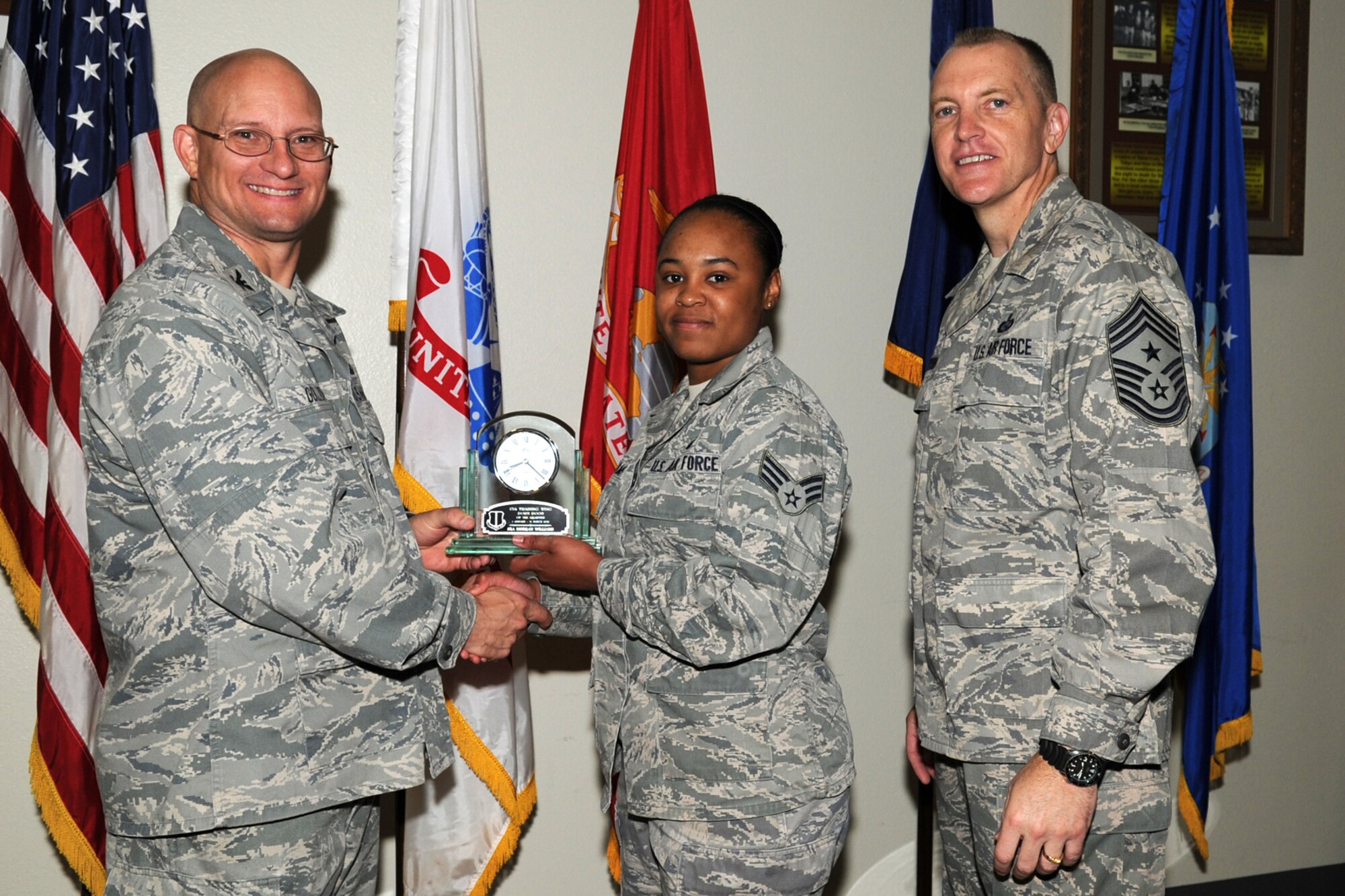 GOODFELLOW AIR FORCE BASE, Texas -- Col. William Golladay, 17th Training Wing Vice Commander, and Chief Master Sgt. Scott Lumpkin, 17th TRW Command Chief, present the 17th Training Wing Dorm Room of the Quarter to Senior Airman Morgan Williams, 17th Force Support Squadron, during the wing quarterly awards ceremony April 24. (U.S. Air Force photo/Staff Sgt. Laura R. McFarlane)