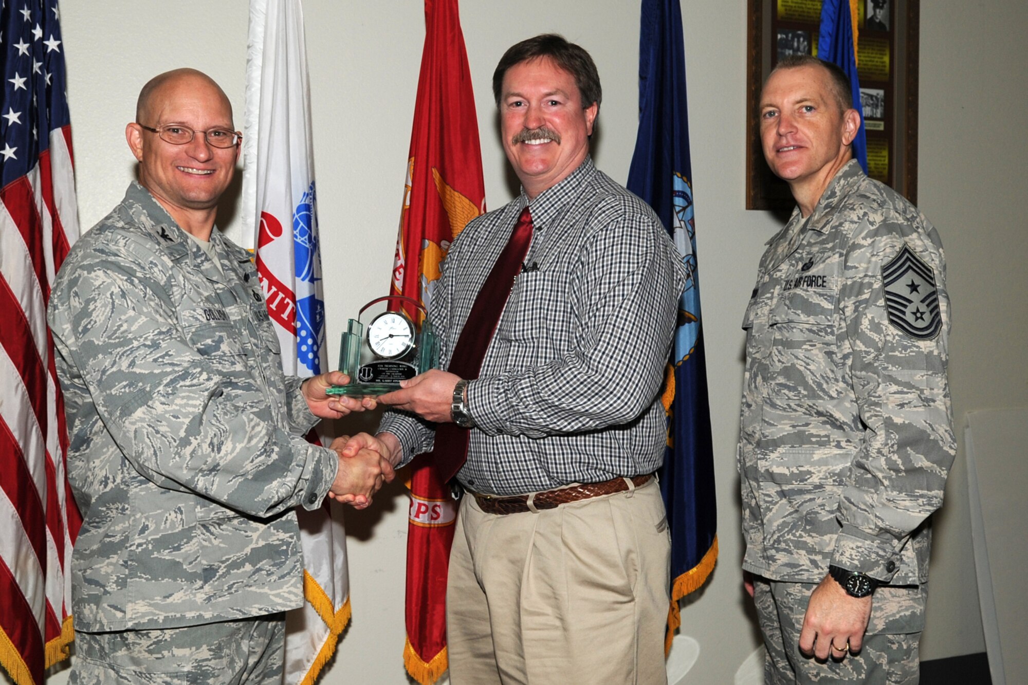 GOODFELLOW AIR FORCE BASE, Texas -- Col. William Golladay, 17th Training Wing Vice Commander, and Chief Master Sgt. Scott Lumpkin, 17th TRW Command Chief, present the 17th Training Wing Civilian Supervisor of the Quarter Category II to Larry Stewart, 17th Communications Squadron, during the wing quarterly awards ceremony April 24. (U.S. Air Force photo/Staff Sgt. Laura R. McFarlane)