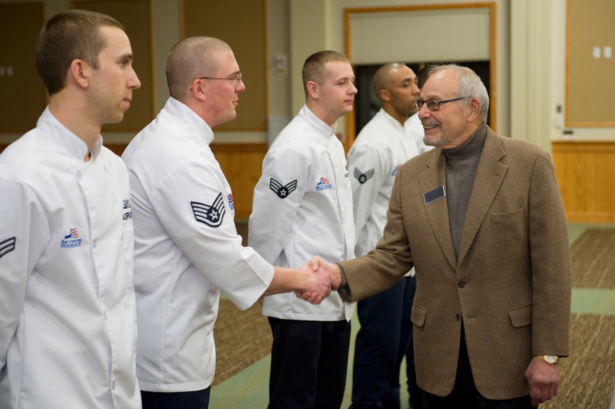 Jeff Berlind, a member of the National Restaurant Association, shakes the hands of several Team Malmstrom chefs. Berlind was one of three association members who came to Malmstrom in February to evaluate chefs on various food-service aspects for the Hennessy awards. (U.S. Air Force photo/Beau Wade)