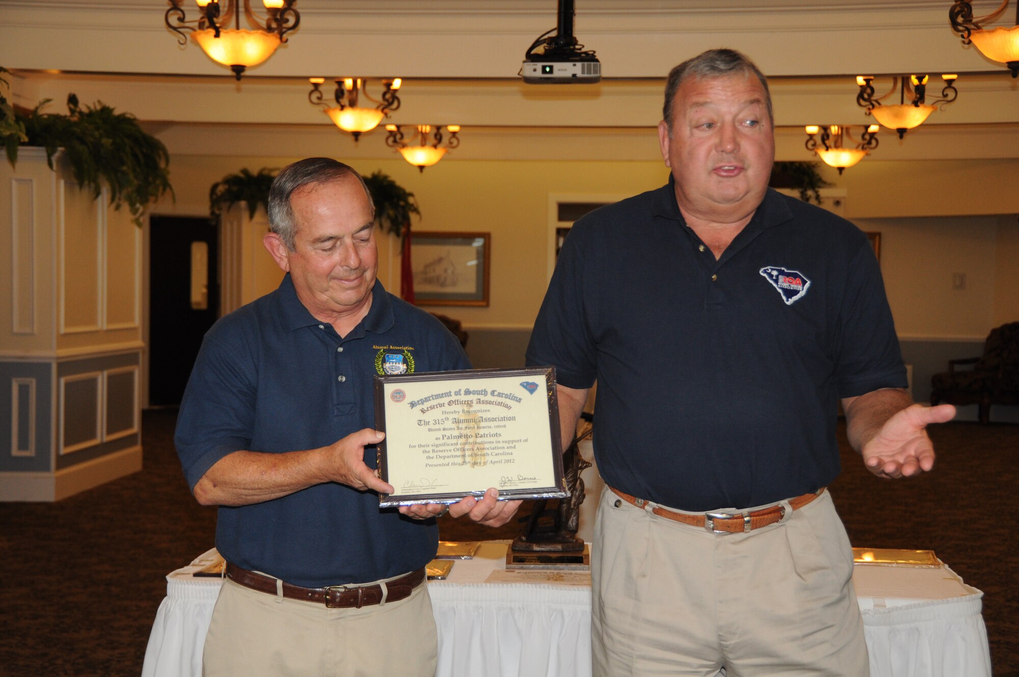 Col. (Ret) Gary L. Cook speaks about the outstanding and sustained contributions made by Chief Master Sgt. (Ret) Dick Fuller during the Department of South Carolina Reserve Officers Association awards luncheon April 28, 2012 at the Marine Corps Recruit Depot, Paris Island, S.C. The ROA event recognized the accomplishments of various South Carolina reserve organizations and ROA members, and Chief Fuller was the recipient of two awards at the event. Col. Cook is the former 315 AW commander and Chief Fuller is the current 315th Alumni Association president. (U.S. Air Force Photo/Staff Sgt. Shane Ellis)