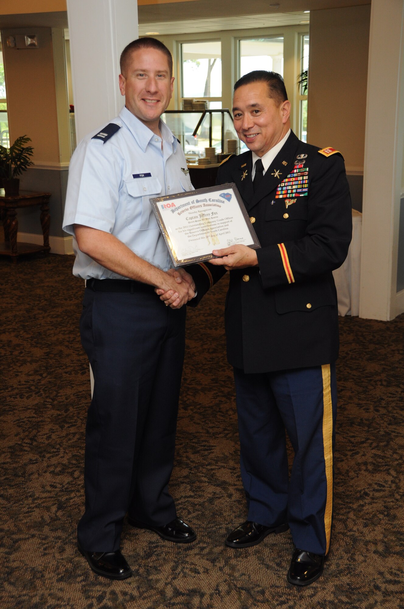 Capt. Jeffrey Fox is presented the U.S. Air Force Reserve Junior Officer of the Year Award by Capt. Christopher Cox April 28, 2012 during the Department of South Carolina Reserve Officers Association awards luncheon at Marine Corps Recruit Depot, Paris Island, S.C. The ROA awards luncheon recognized the accomplishments of various South Carolina reserve organizations and ROA members. Captain Fox is a flight nurse with the 315th Aeromedical Evacuation Squadron at joint Base Charleston, and Capt. Cox is the plans operations and training officer with the 415 Chemical Brigade in Greenville, S.C. and the current South Carolina Chapter ROA president. (U.S. Air Force Photo/Staff Sgt. Shane Ellis)