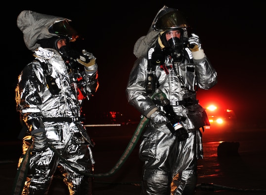 U.S. Air Force Tech. Sgt. Michael Osada, left, and Airman 1st Class Jeremy Stephens, 35th Civil Engineer Squadron firefighters, communicate with other firefighters inside a simulated burning building during an operational readiness exercise at Misawa Air Base, Japan, April 30, 2012. OREs help Misawa's Airmen stay prepared and ready to fight in a deployed environment. (U.S. Air Force Airman 1st Class Kia Atkins/Released)