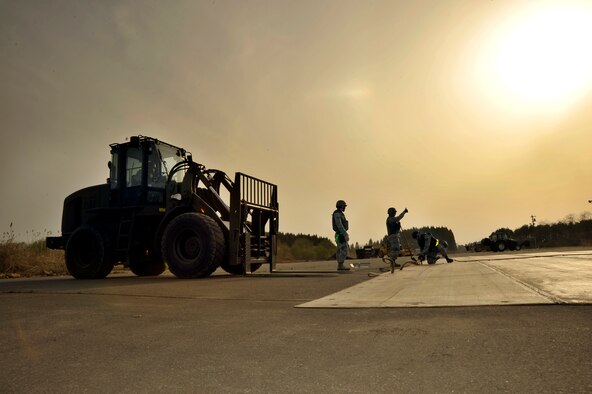 U.S. Air Force Airmen from the 35th Civil Engineer Squadron finish piecing together a mat used to cover simulated runway damage during an operational readiness exercise at Misawa Air Base, Japan, April 28, 2012. The purpose of the exercise is to demonstrate the wing's ability to quickly generate war-ready aircraft. Operational readiness exercises help Airmen develop skills needed in a deployed environment. (U.S. Air Force photo by Staff Sgt. Nathan Lipscomb/Released)