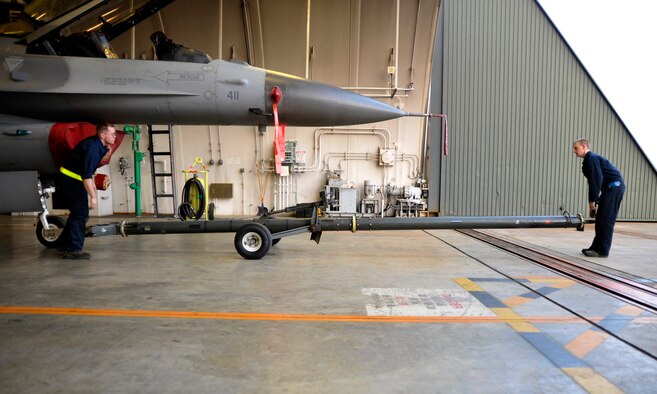 U.S. Air Force Staff Sgt. Joshua Morgan, left, and Airman 1st Class Casey Nicholson, 35th Aircraft Maintenance Squadron crew chiefs, prepare to tow an F-16 Fighting Falcon during an operational readiness exercise at Misawa Air Base, Japan, April 28, 2012. The purpose of the exercise is to demonstrate the wing's ability to quickly generate and employ war-ready aircraft. (U.S. Air Force photo by Staff Sgt. Nathan Lipscomb/Released)