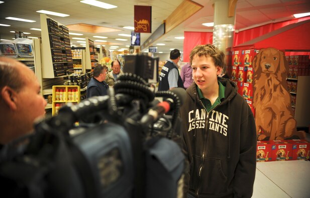 Daniel Swanson, an 18-year-old Spokane, Wash., resident and service dog recipient, talks with a member of the local media about how important receiving his new service dog from Canine Assistants is to him during an event in the commissary at Fairchild Air Force Base, Wash., April 27, 2012. Canine Assistants, a non-profit organization sponsored by Milk-Bone, a Del Monte subsidiary, and the Defense Commissary Agency along with many other agencies and corporations, has been supporting those in need for more than 12 years. (U.S. Air Force photo by Senior Airman Benjamin Stratton/Released)